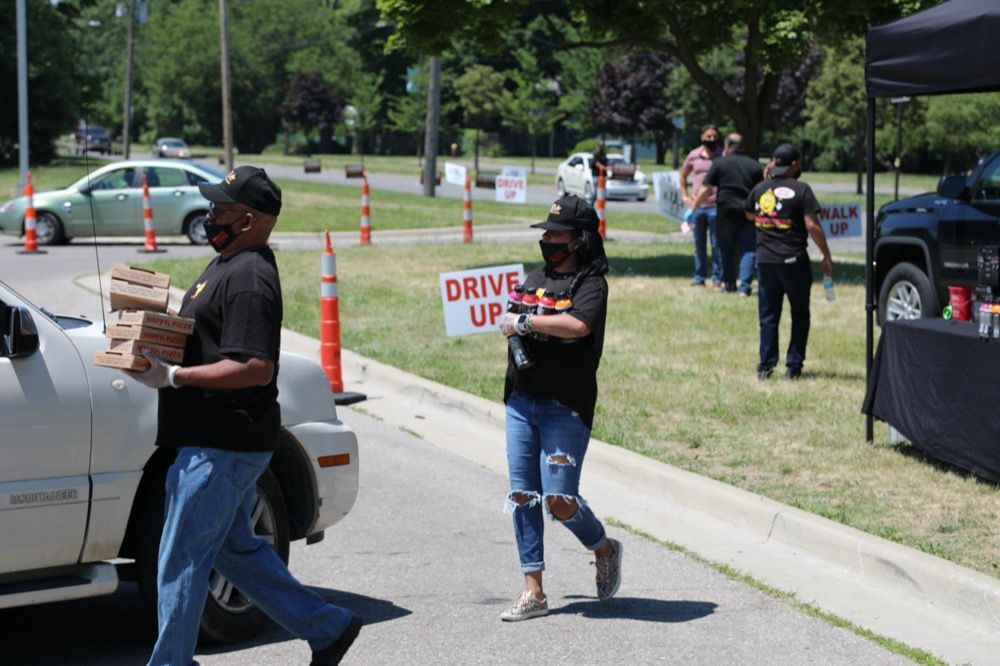 A woman is holding a sign that says drive up