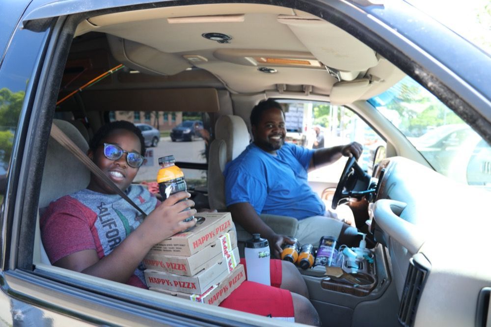 A family receives free food from Happy's Pizza