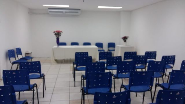 Uma sala com cadeiras azuis e uma mesa branca