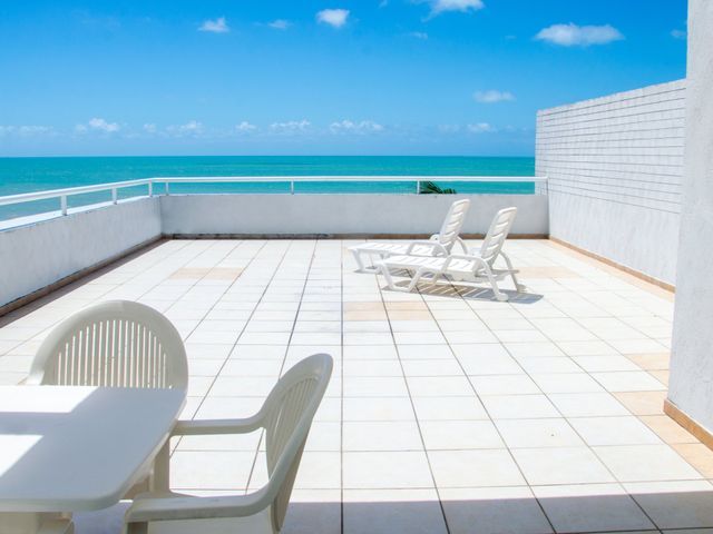 Uma mesa e cadeiras em uma varanda com vista para o oceano