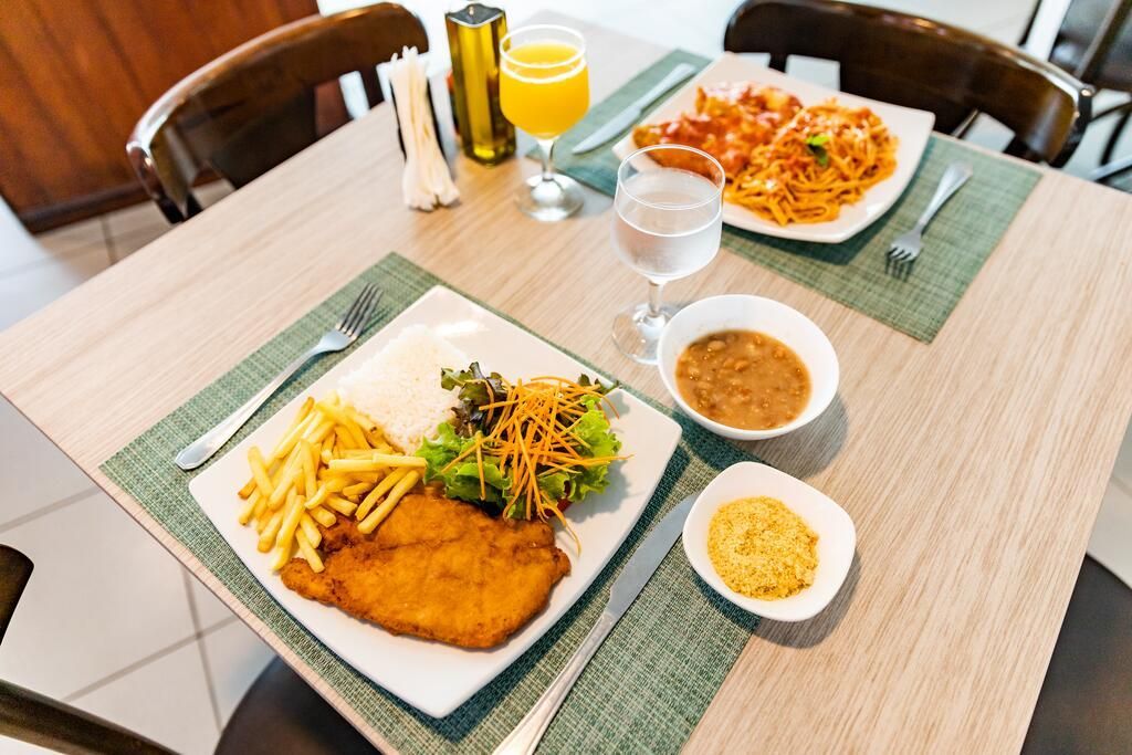 Uma mesa com dois pratos de comida e um copo de água sobre ela.
