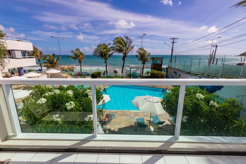 Uma varanda com vista para a piscina e o oceano.
