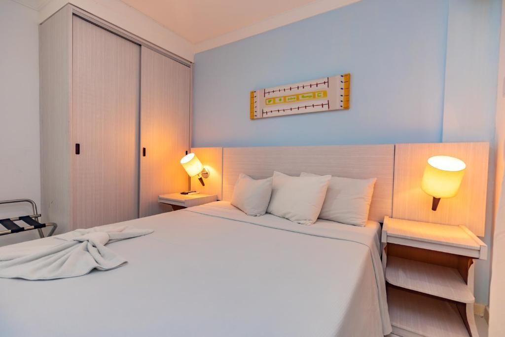 Um quarto de hotel com uma cama grande e duas mesas de cabeceira