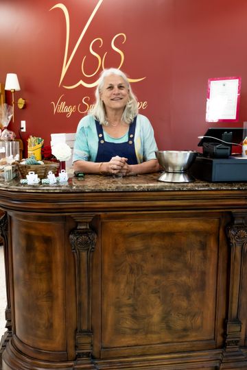 A woman is sitting at a counter in a store.