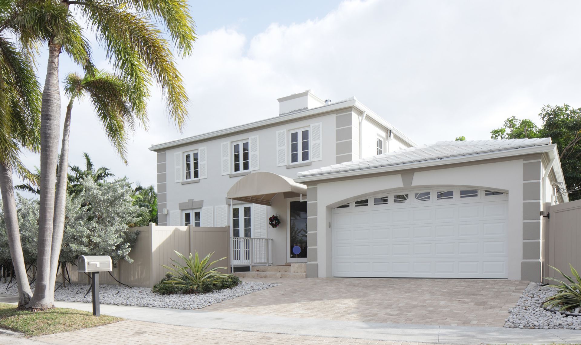 A white house with a palm tree in front of it