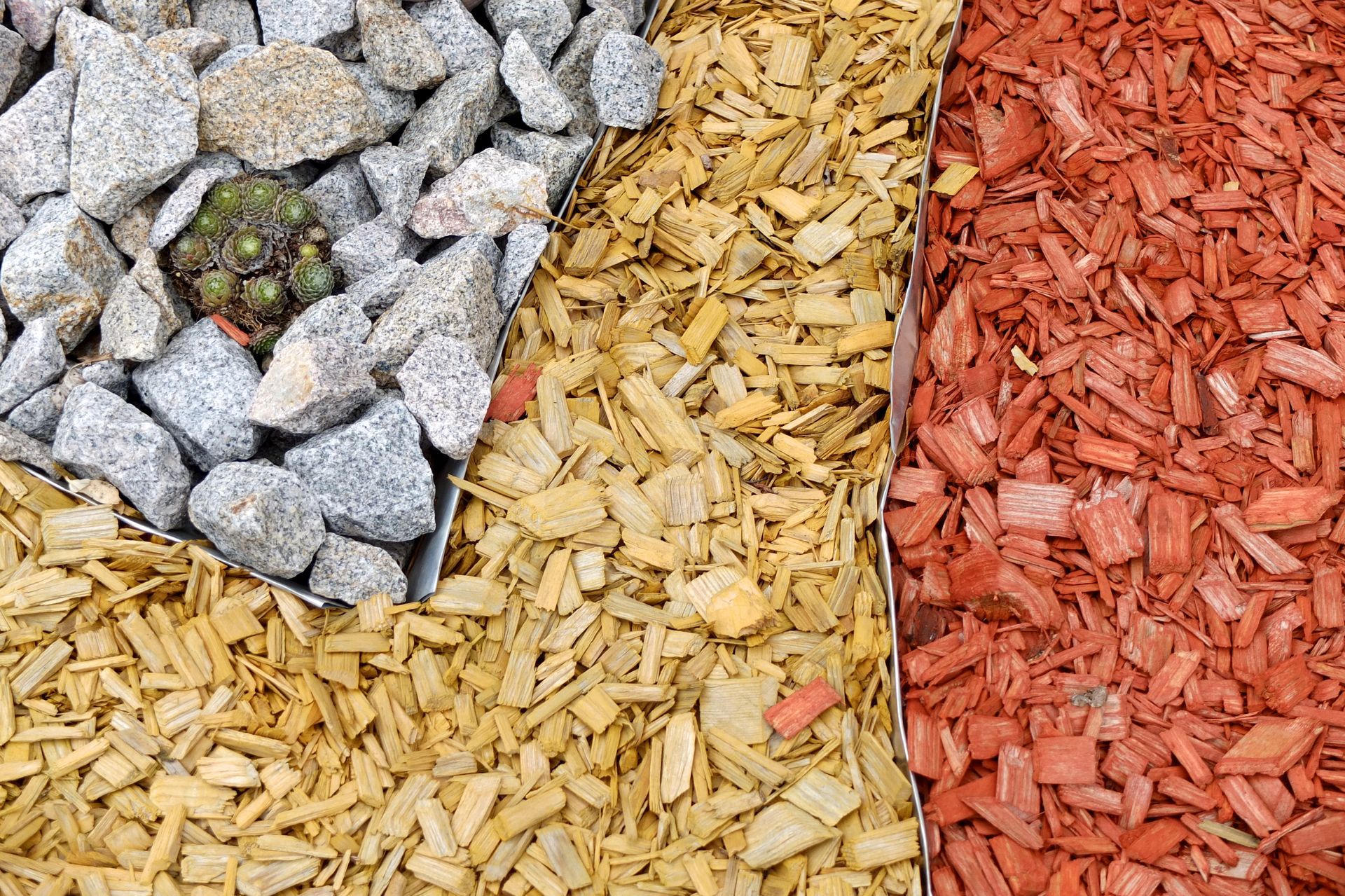 Colorful ground cover sections: gray rocks, tan mulch, and red mulch separated into panels