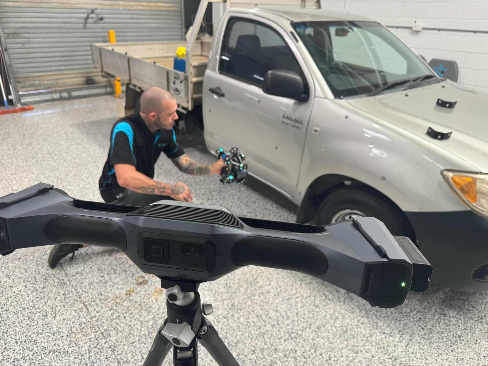 A man is using a 3d scanner to scan a truck in a garage. — 3D Tech In Port Macquarie, NSW