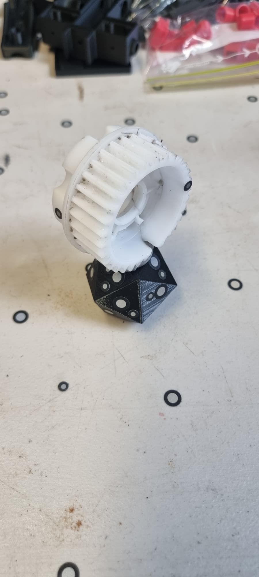 A White Gear is Sitting on Top of a Black Dice on a Table — 3D Tech In Newcastle, NSW