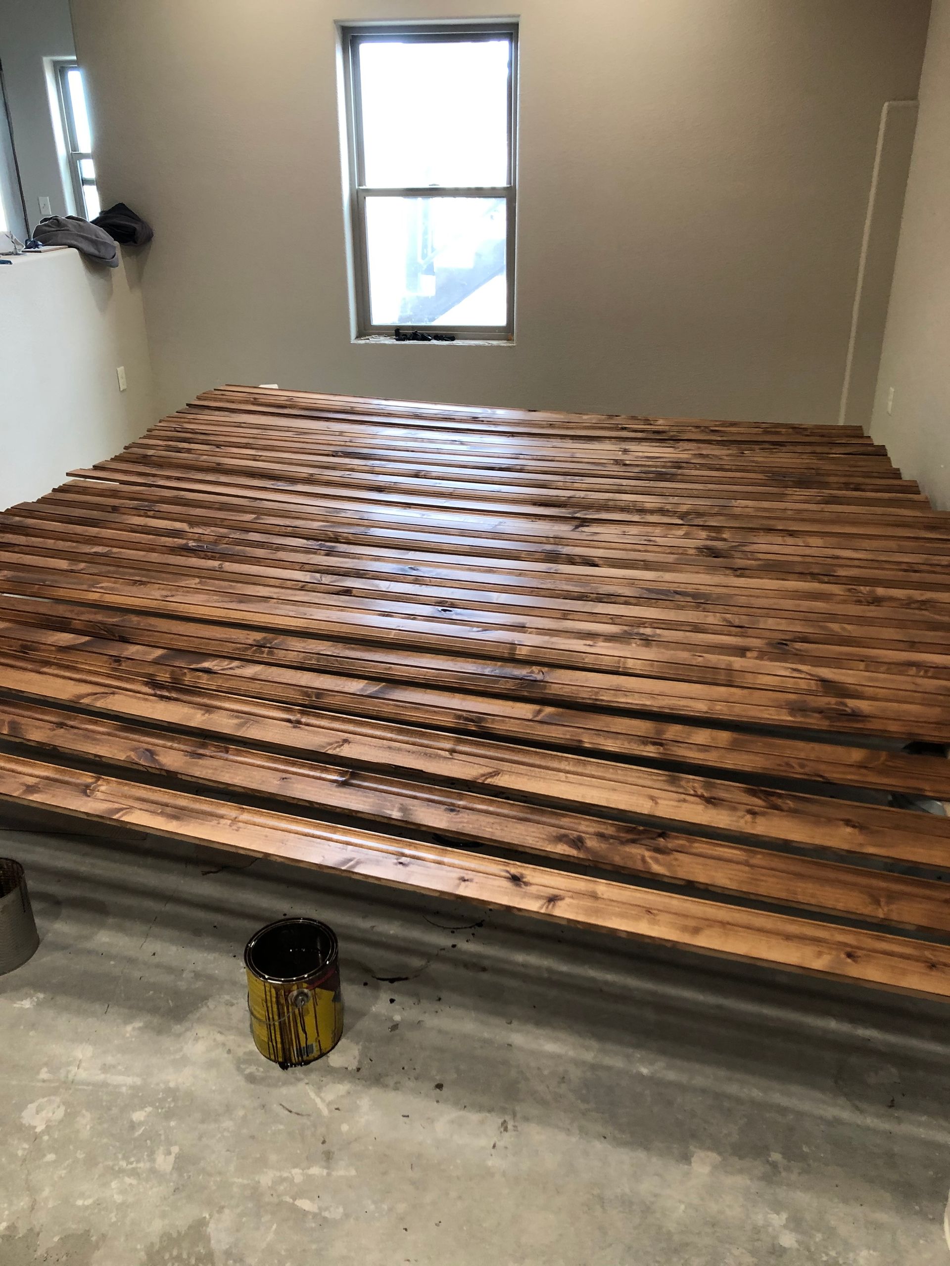 A Room With A Large Wooden Floor And A Window