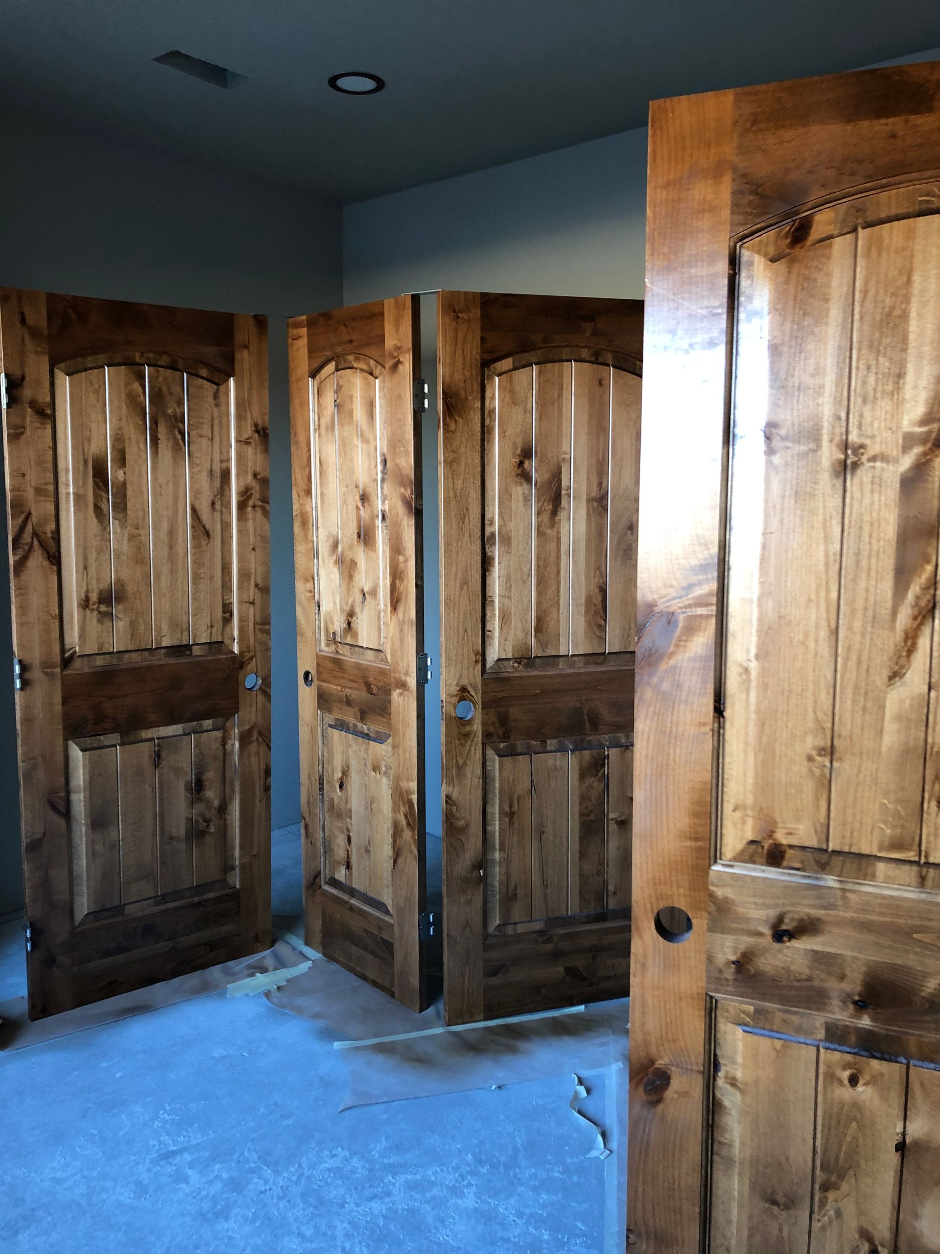 A Room With Three Wooden Doors That Are Open
