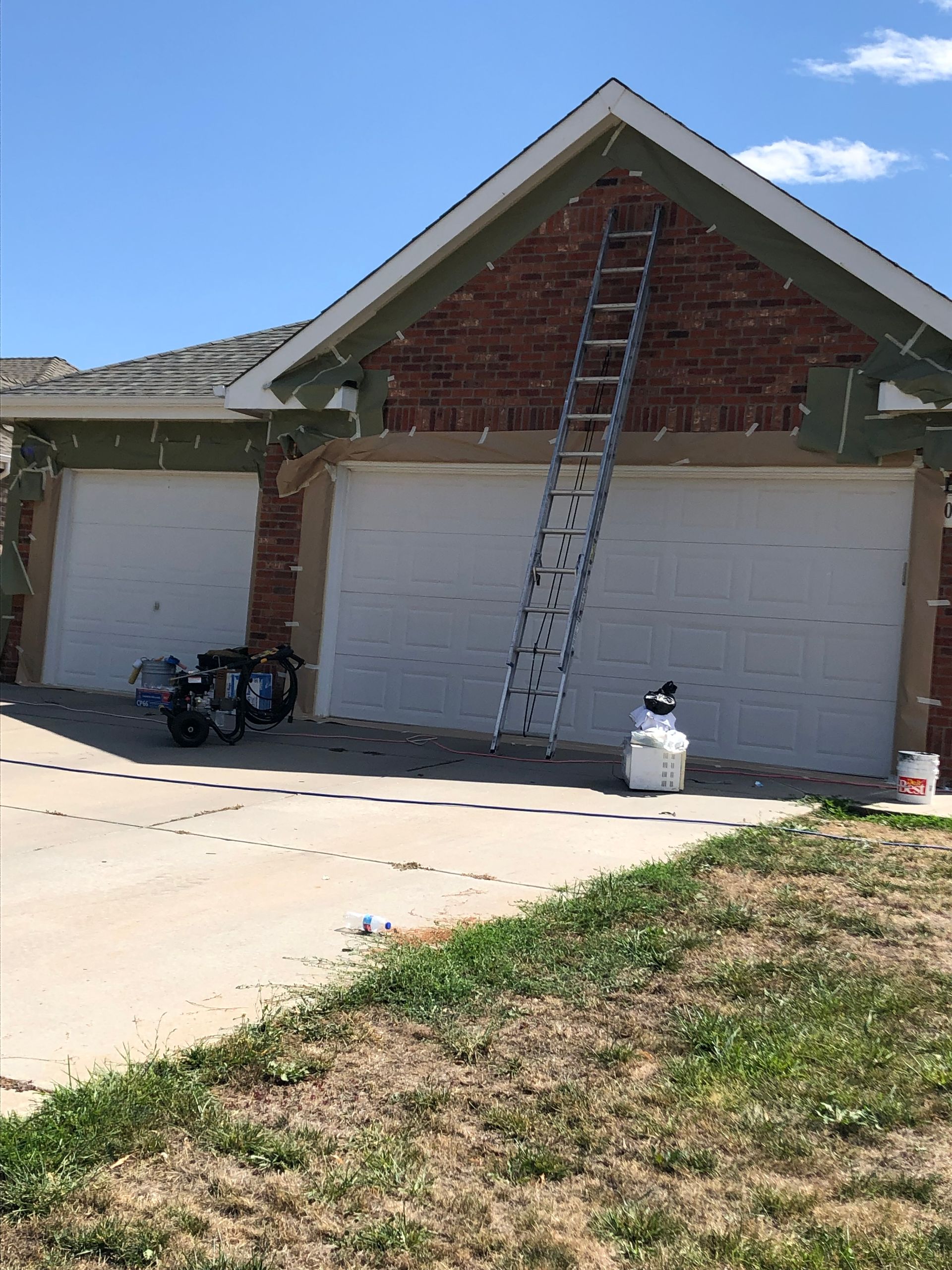 A House Is Being Painted With A Ladder Hanging From The Roof