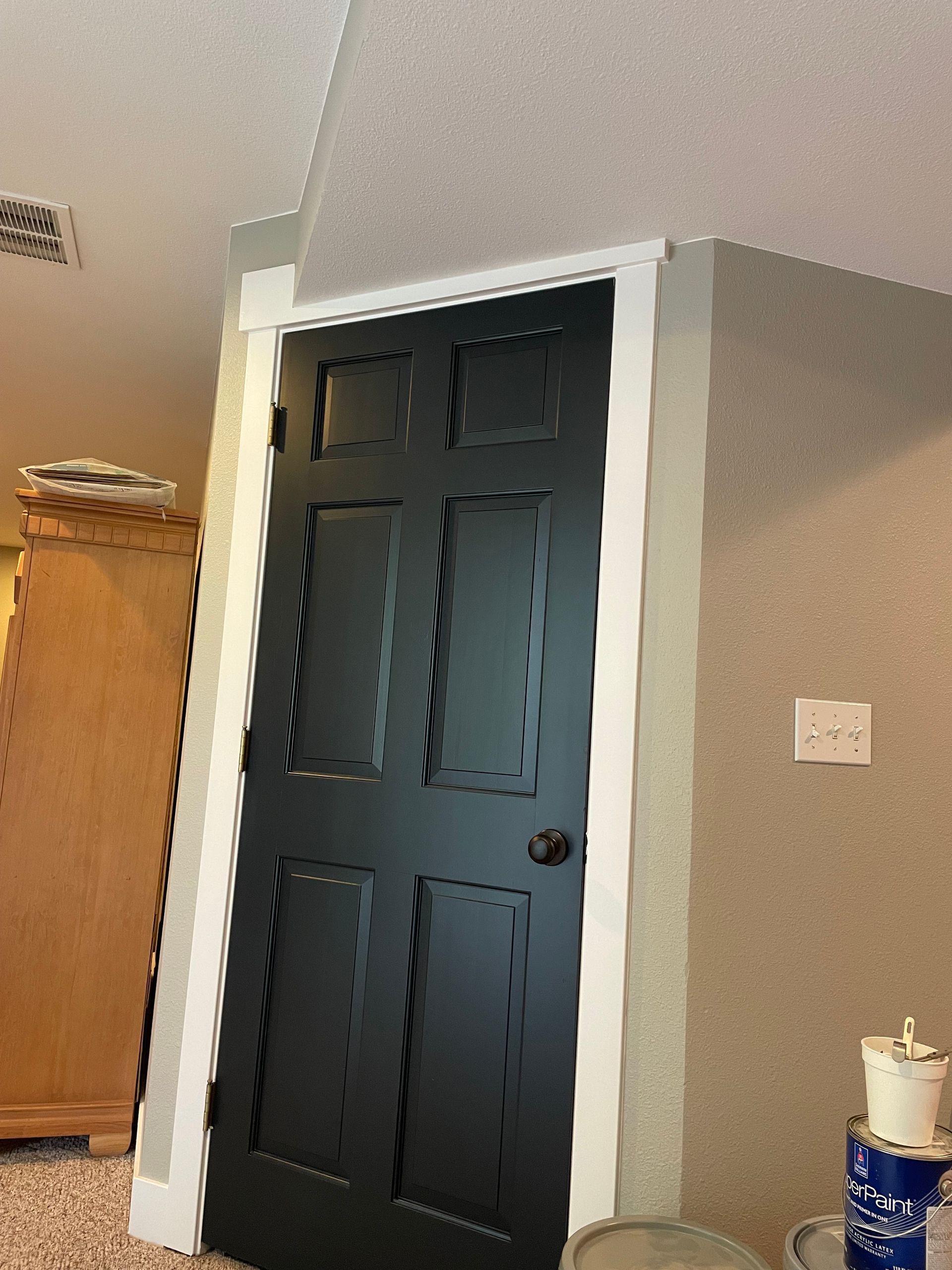A Black Door With A White Trim Is In A Room