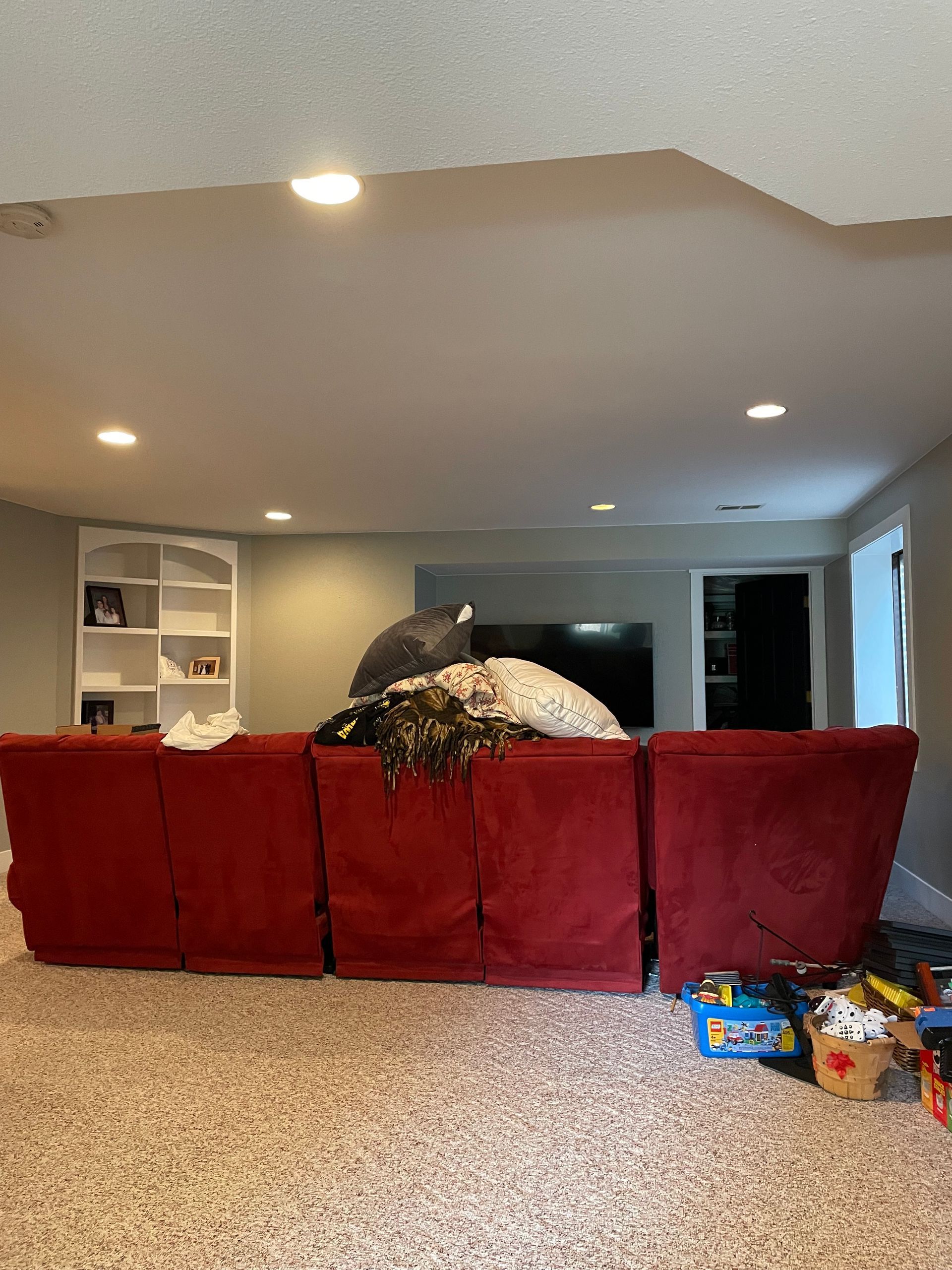 A Living Room With A Red Couch And A Tv