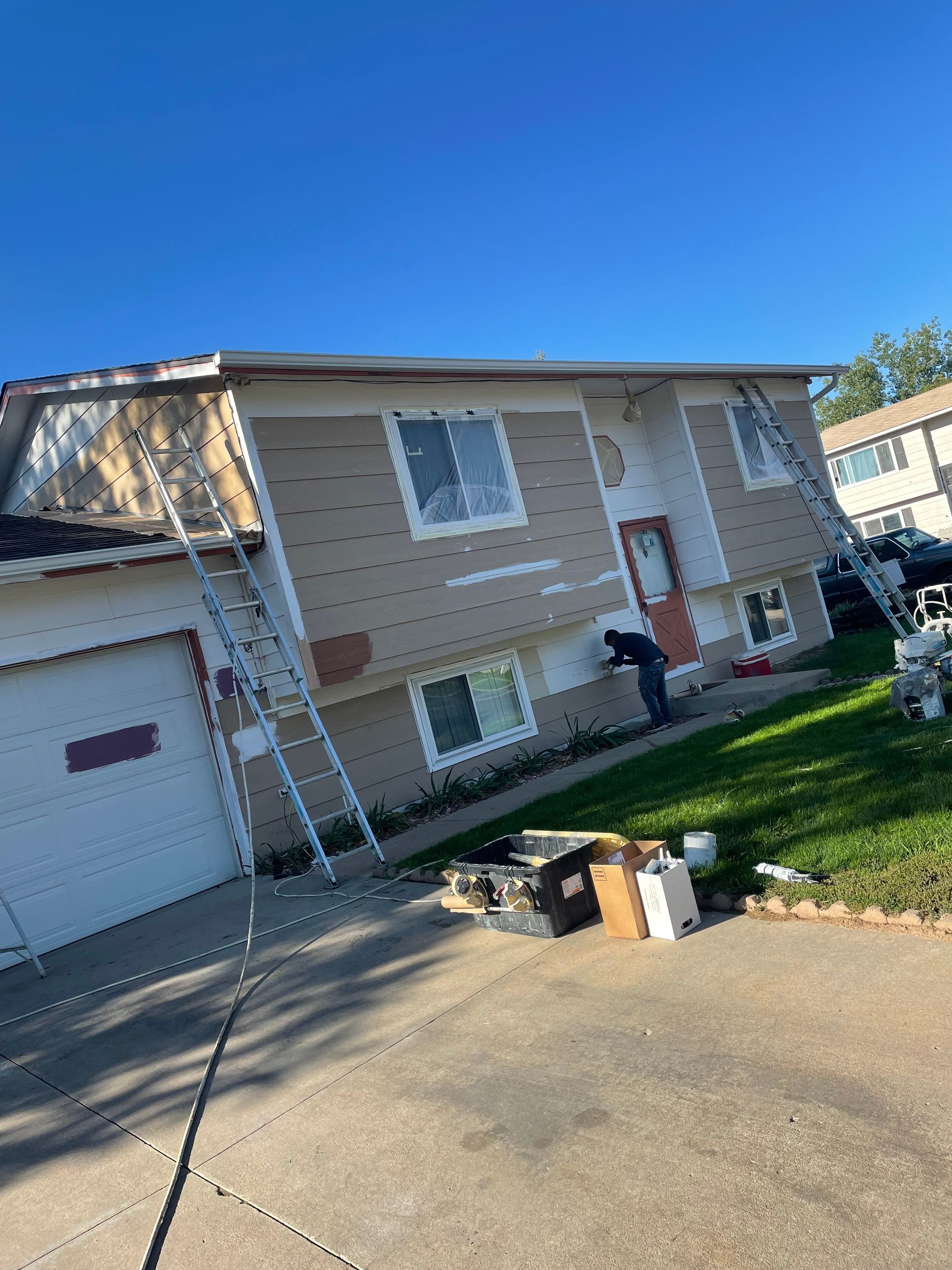 A Man Is Painting The Side Of A House