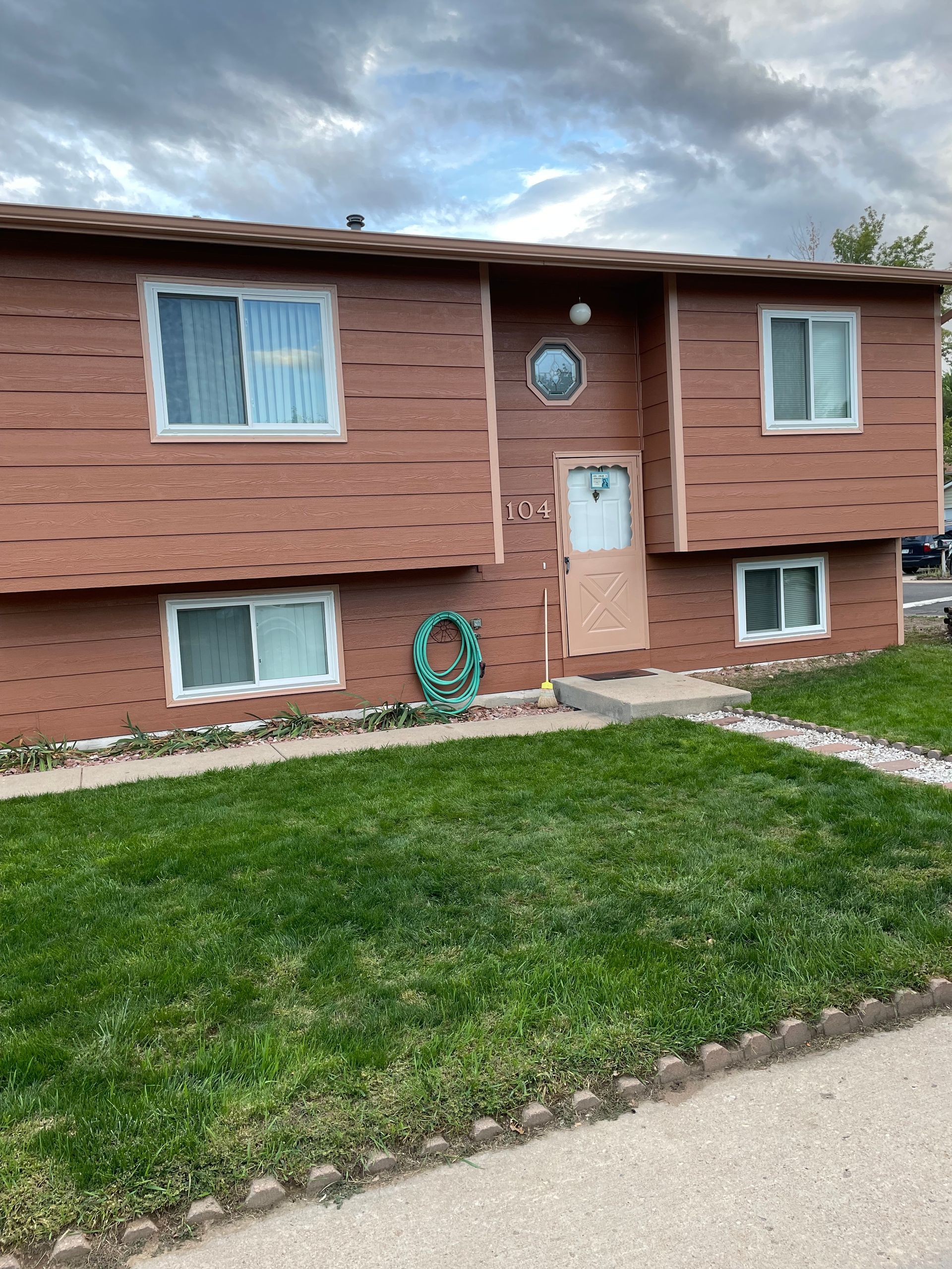 A Brick House With A Lush Green Lawn In Front Of It