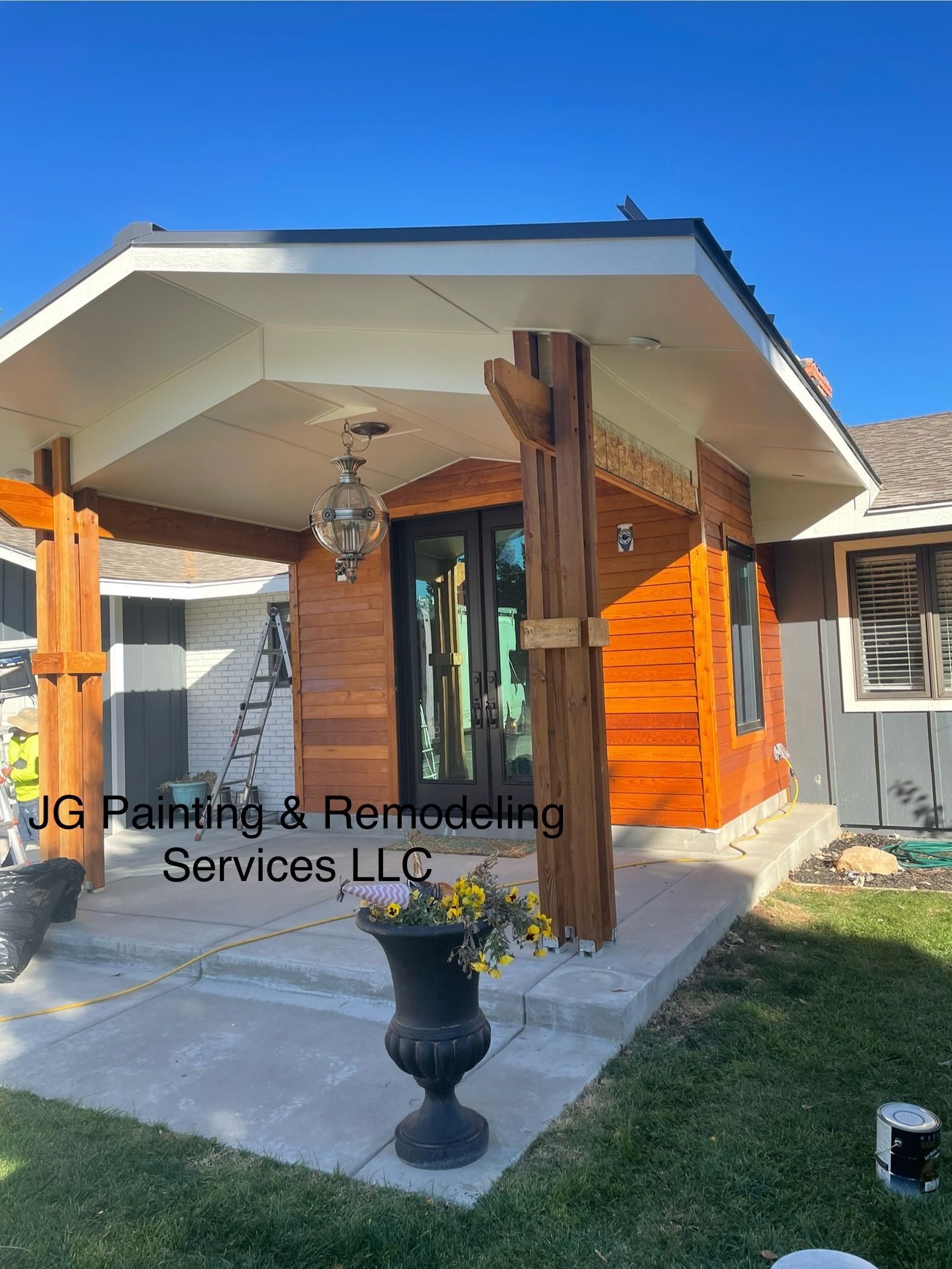 A Small Wooden House With A Porch And A Vase Of Flowers In Front Of It