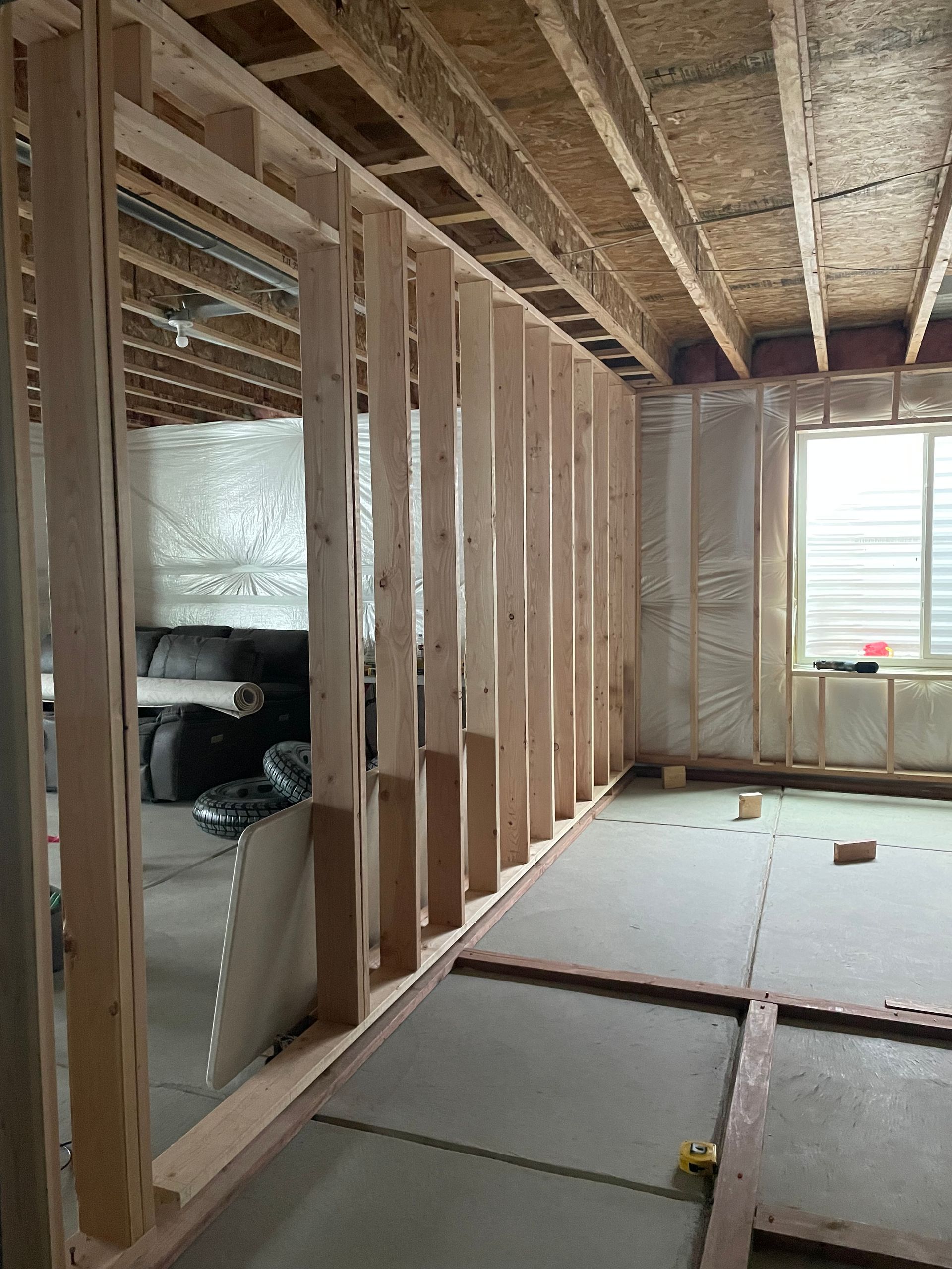 A Room That Is Being Built With A Car In The Background