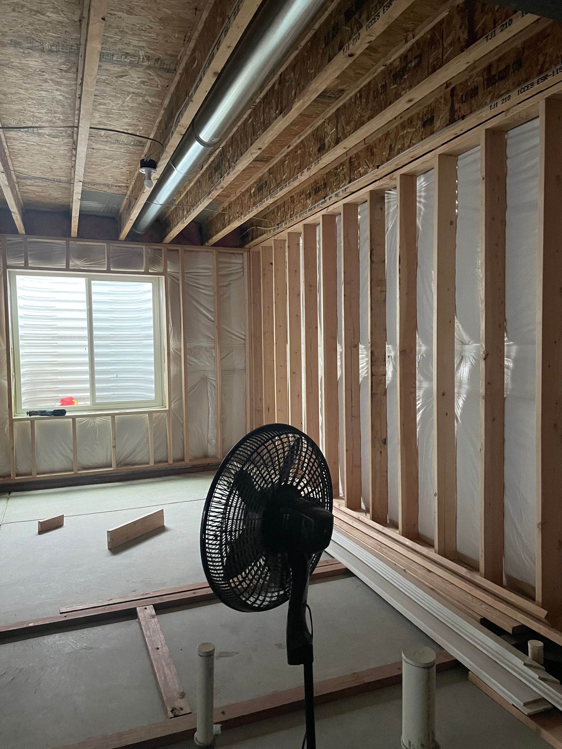 A Fan Is Sitting In The Middle Of A Room Under Construction