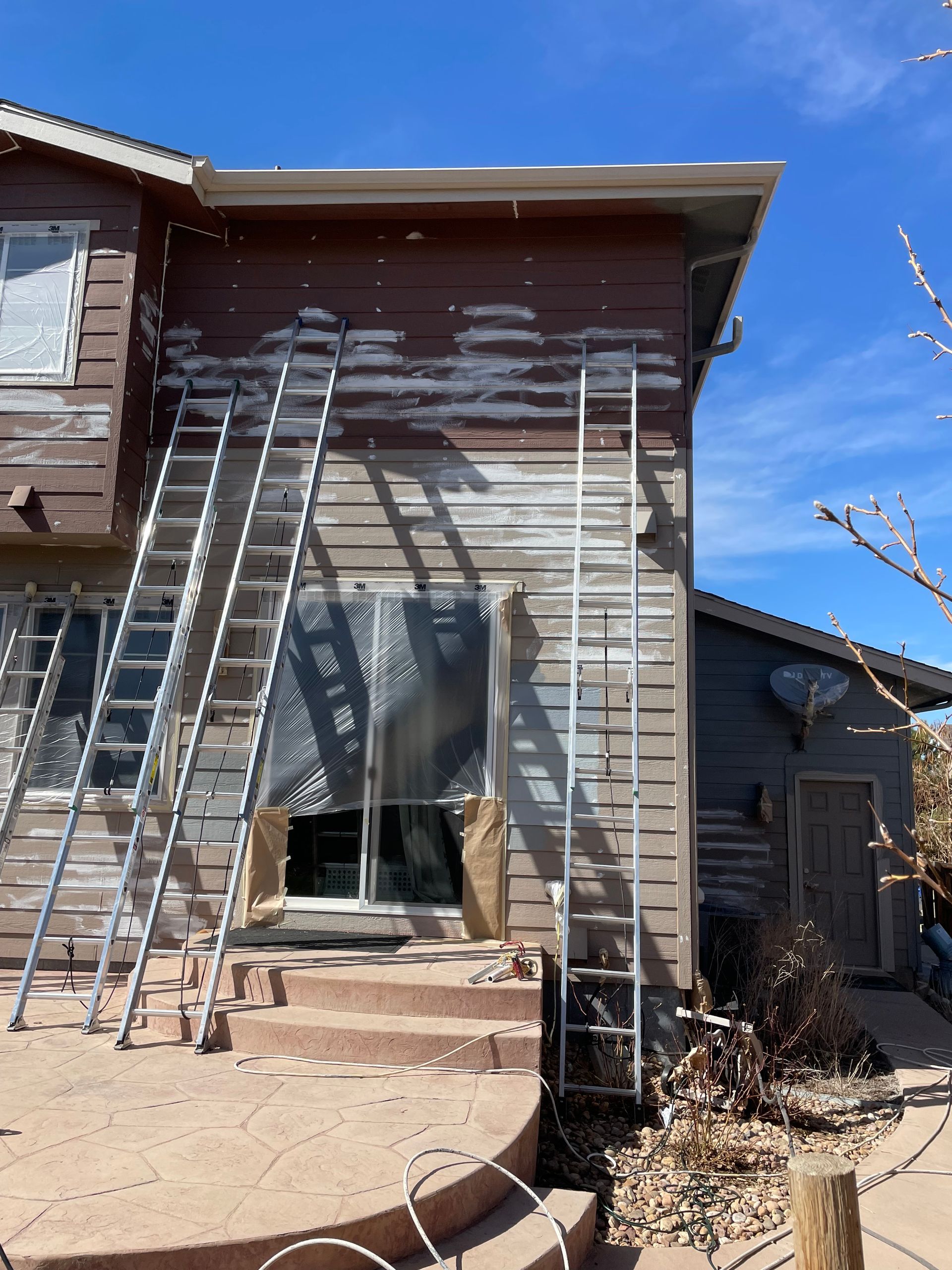 A House Is Being Painted With A Ladder On The Side Of It