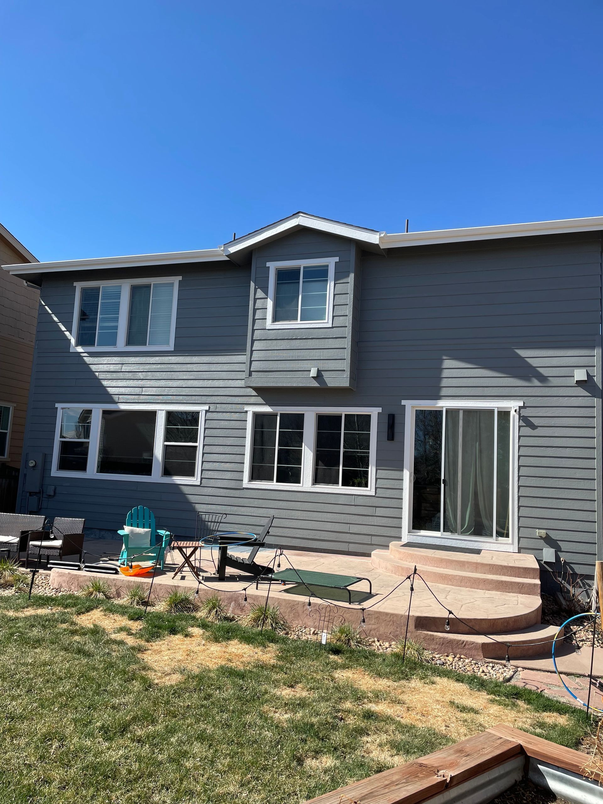 The Back Of A House With A Lot Of Windows And A Sliding Glass Door