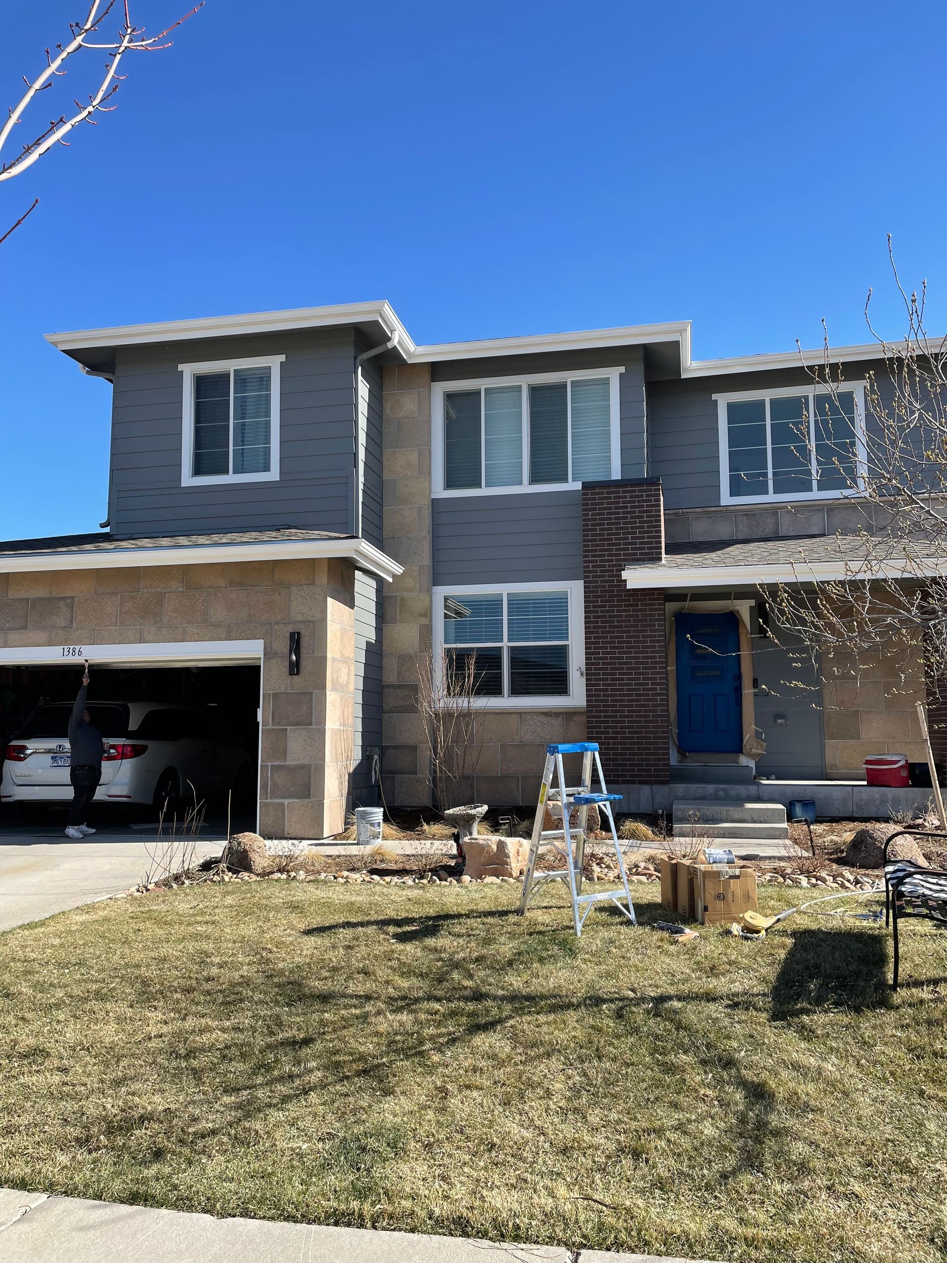 A Large House With A Blue Door Is Being Painted
