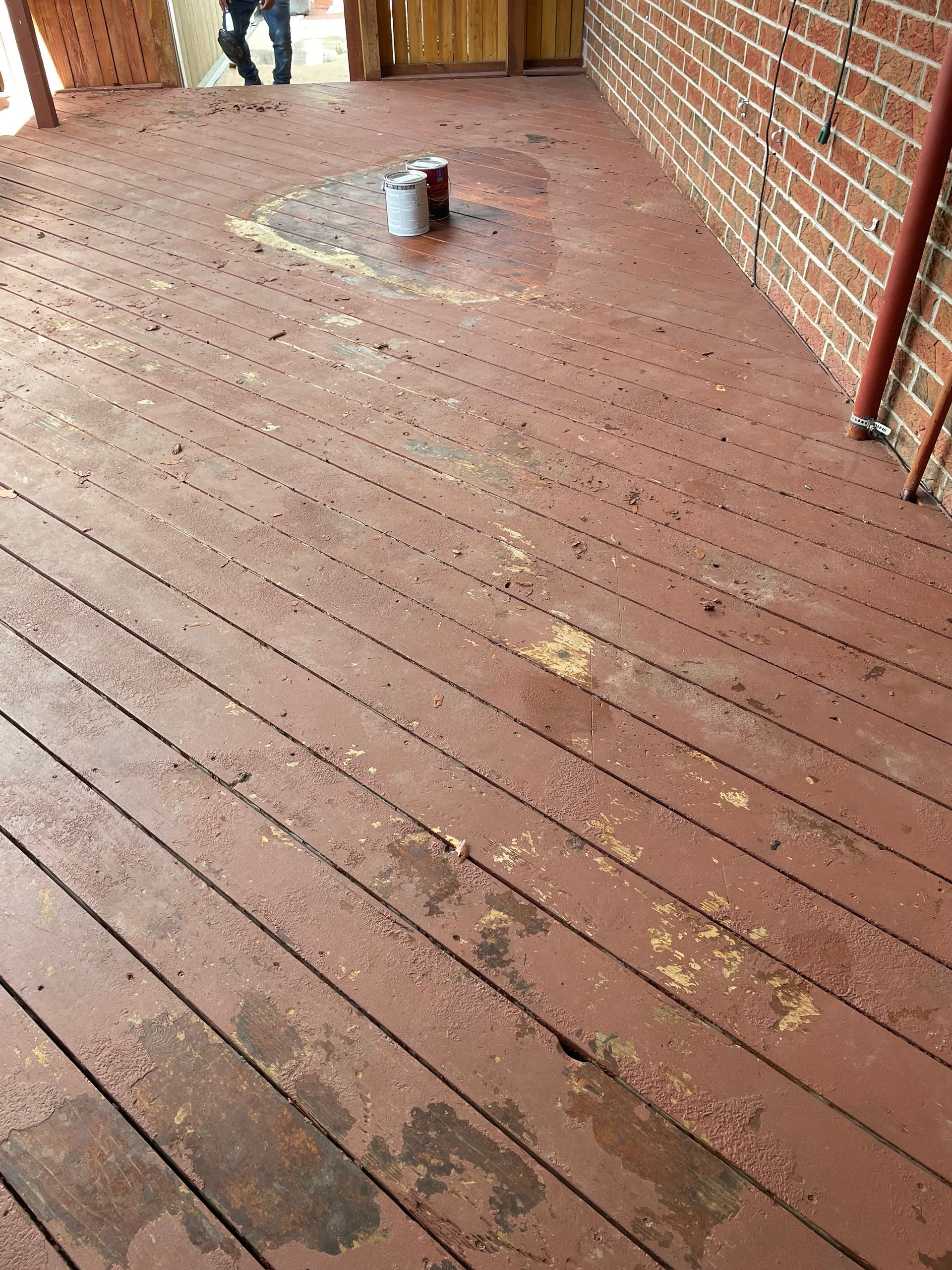 A Wooden Deck With A Bucket Of Paint On It