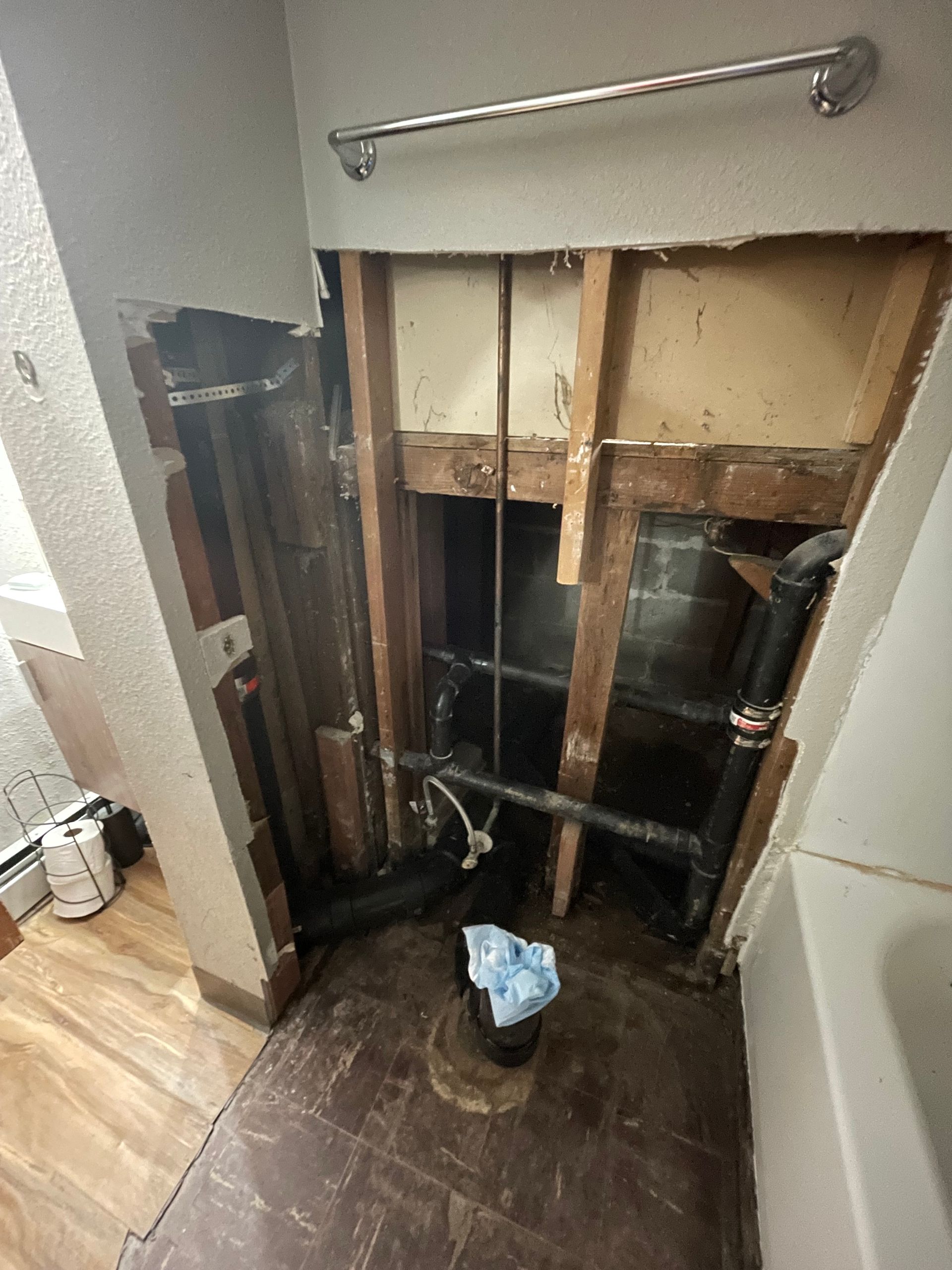 A Bathroom With A Hole In The Wall And Pipes Coming Out Of It