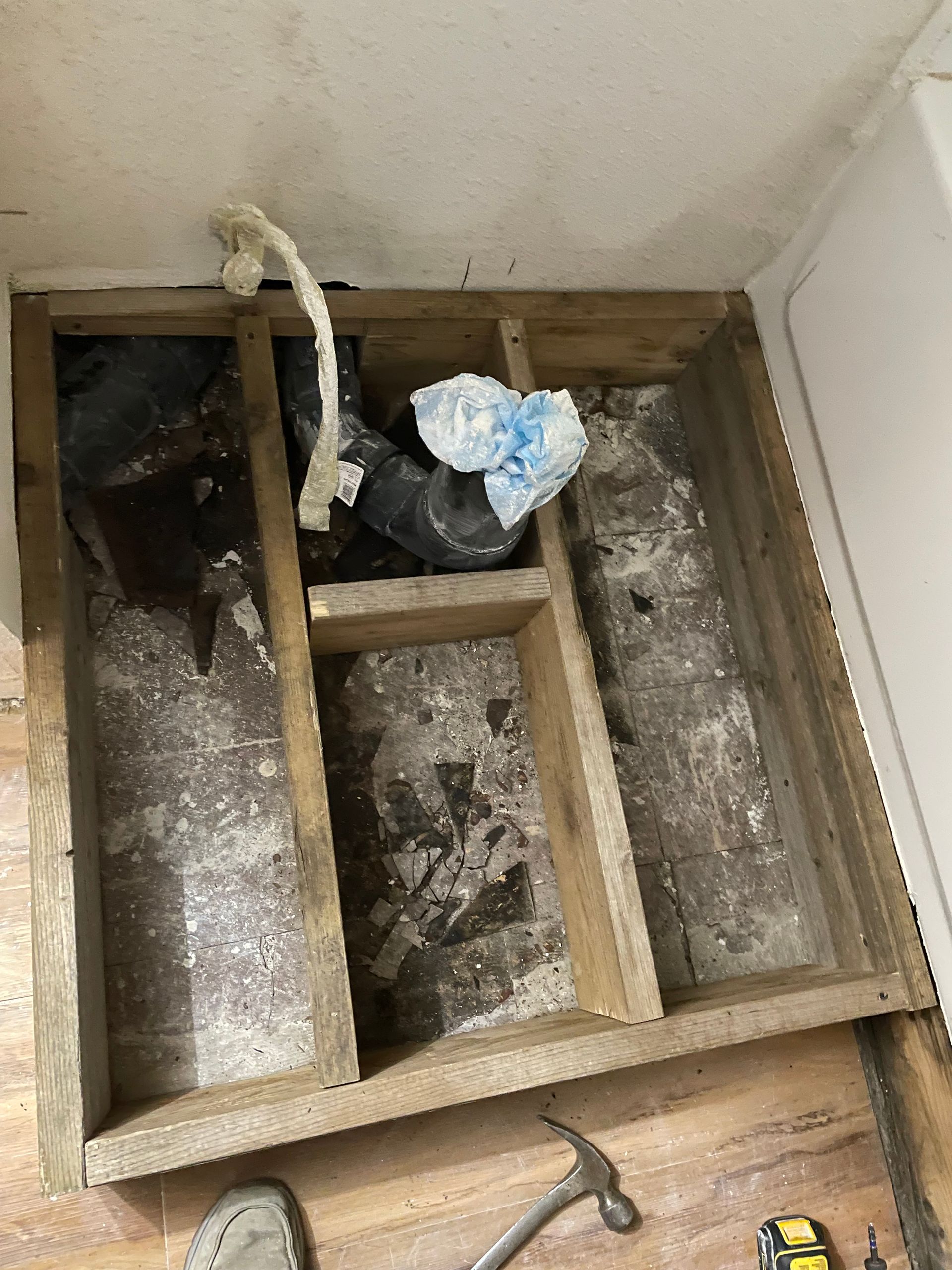 A Wooden Box Is Sitting On A Wooden Floor Next To A Hammer