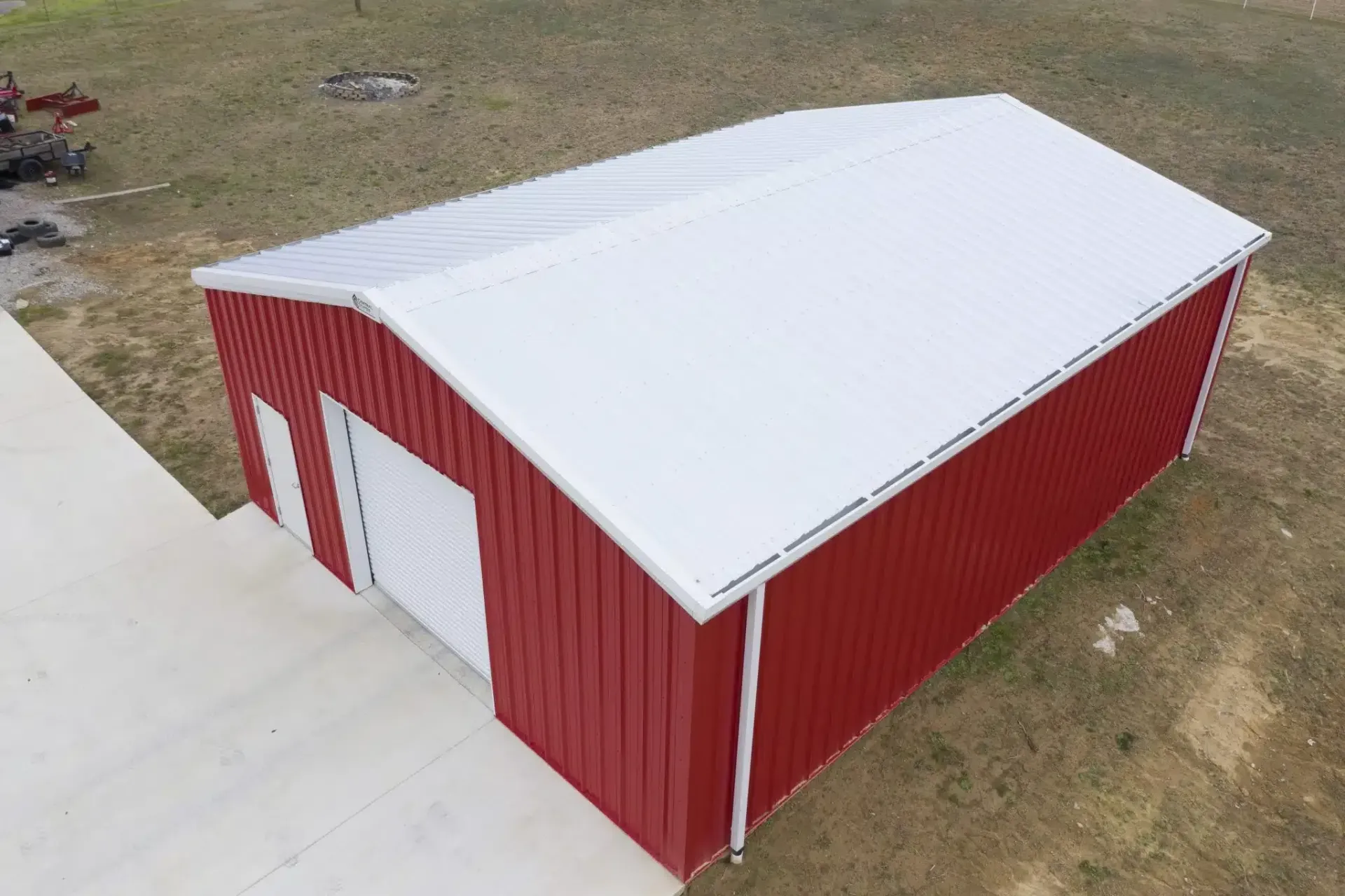 an aerial view of a red barn with a white roof .