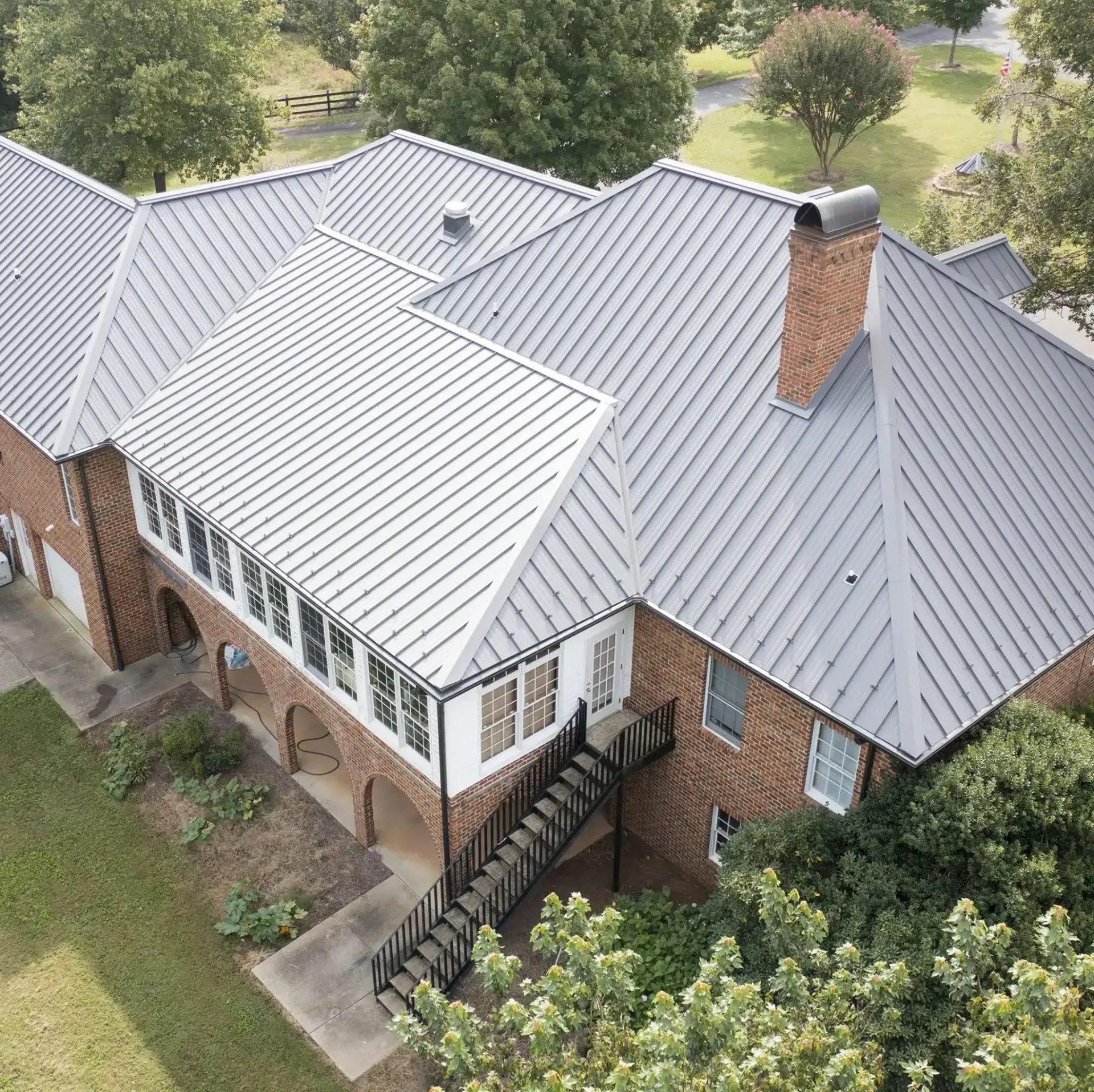 an aerial view of a large brick house with a metal roof .