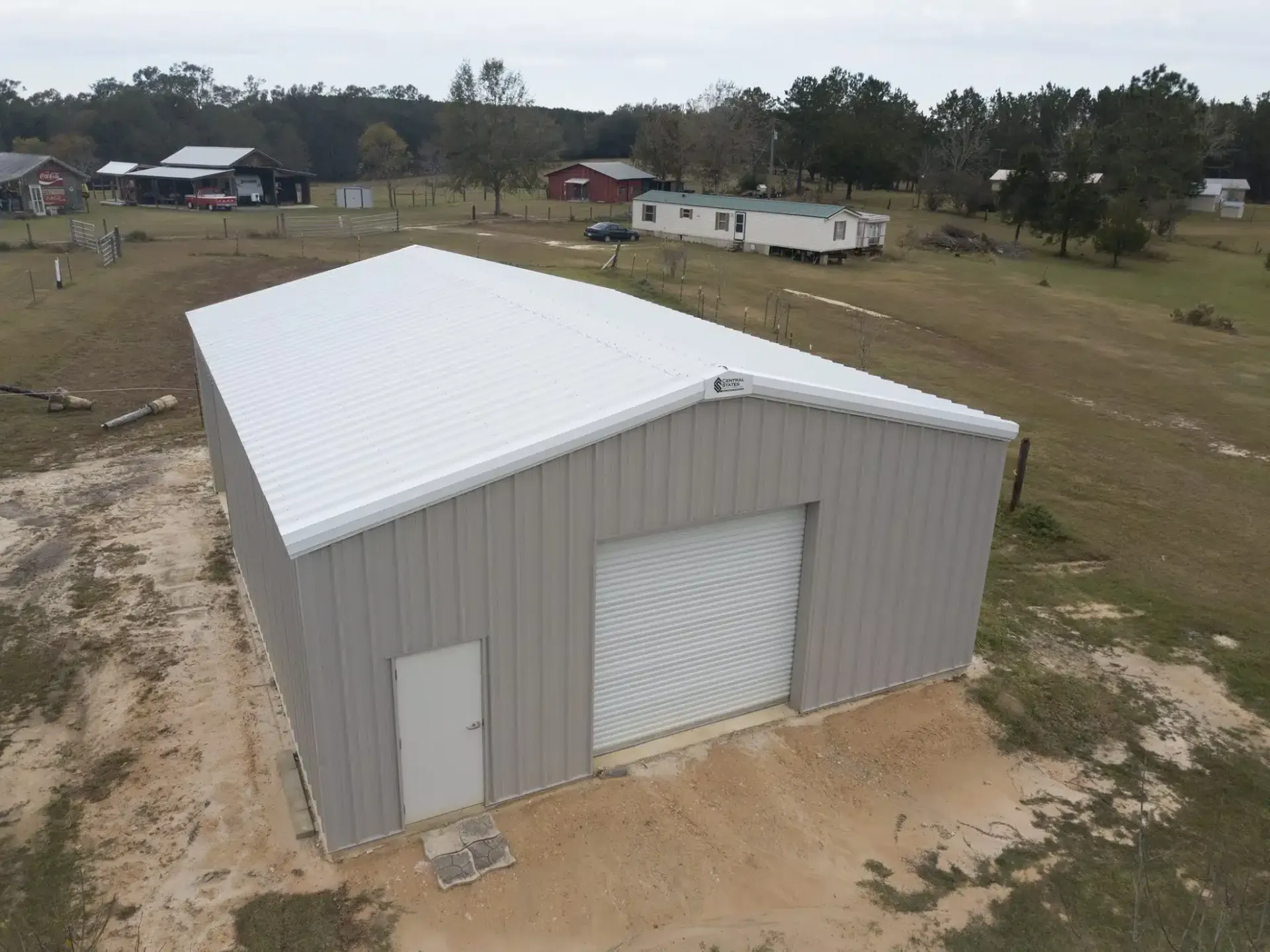 an aerial view of a metal building with a white roof