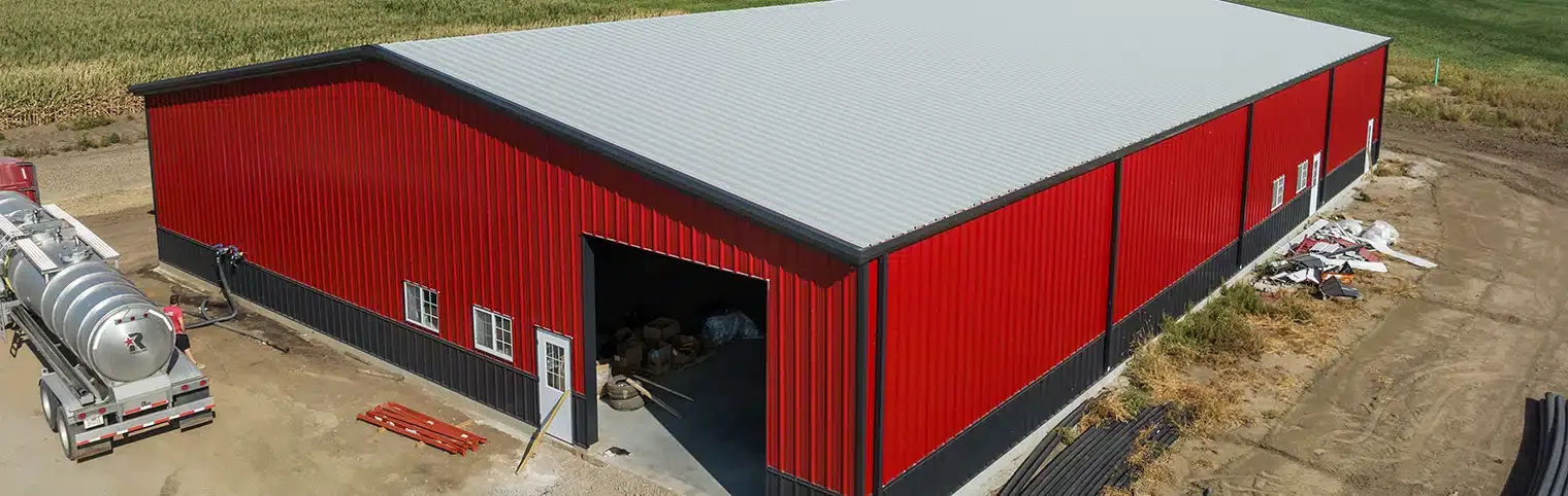 an aerial view of a red metal building with a white roof .