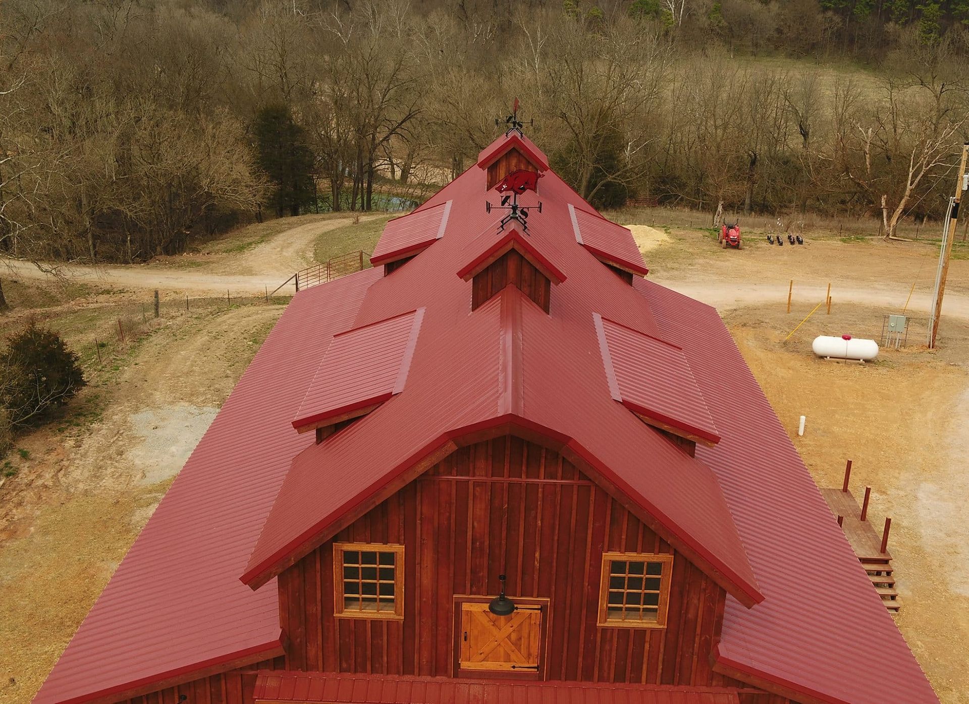 an aerial view of a barn with a red roof