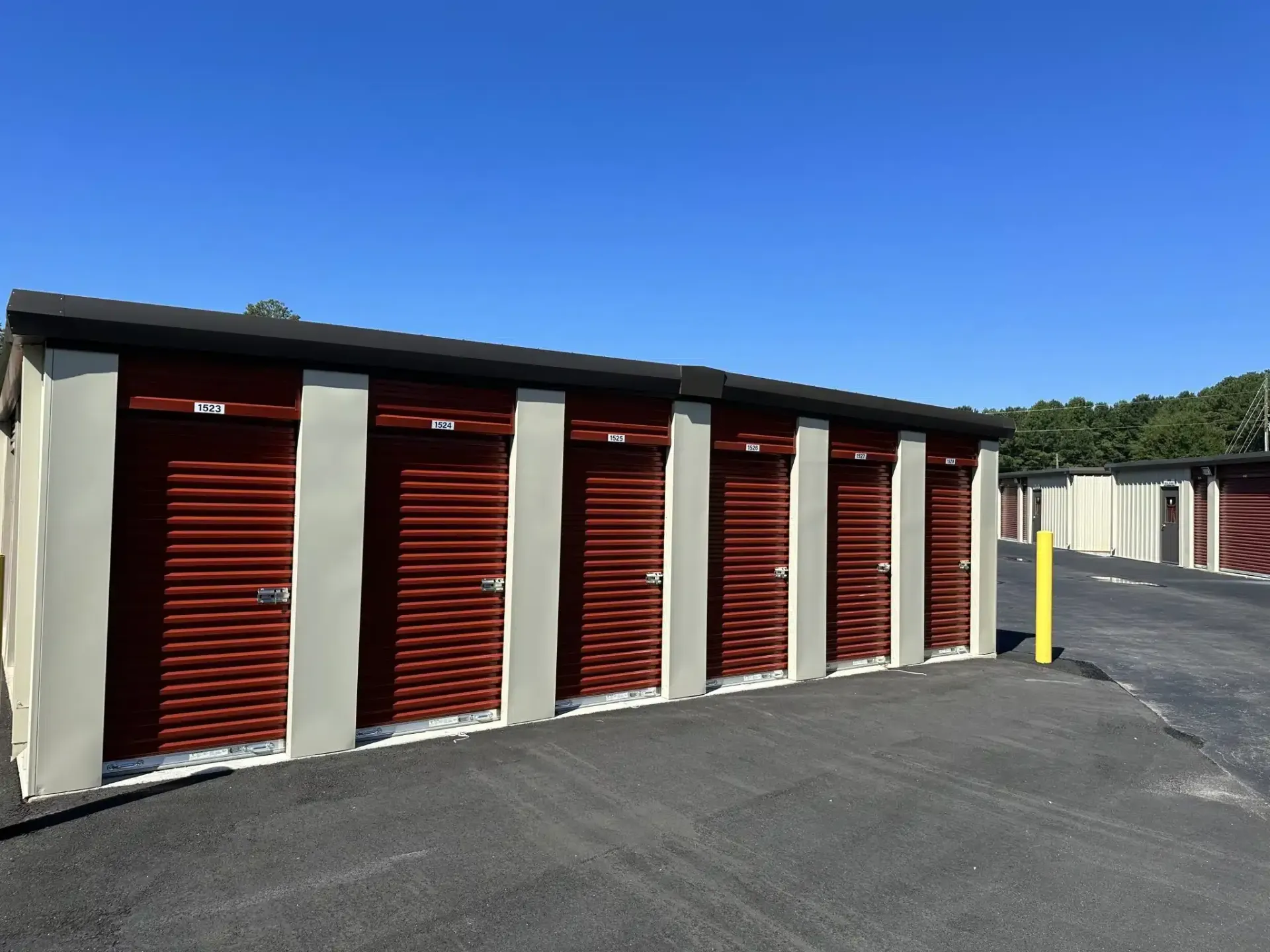 a row of storage units with red doors on a sunny day