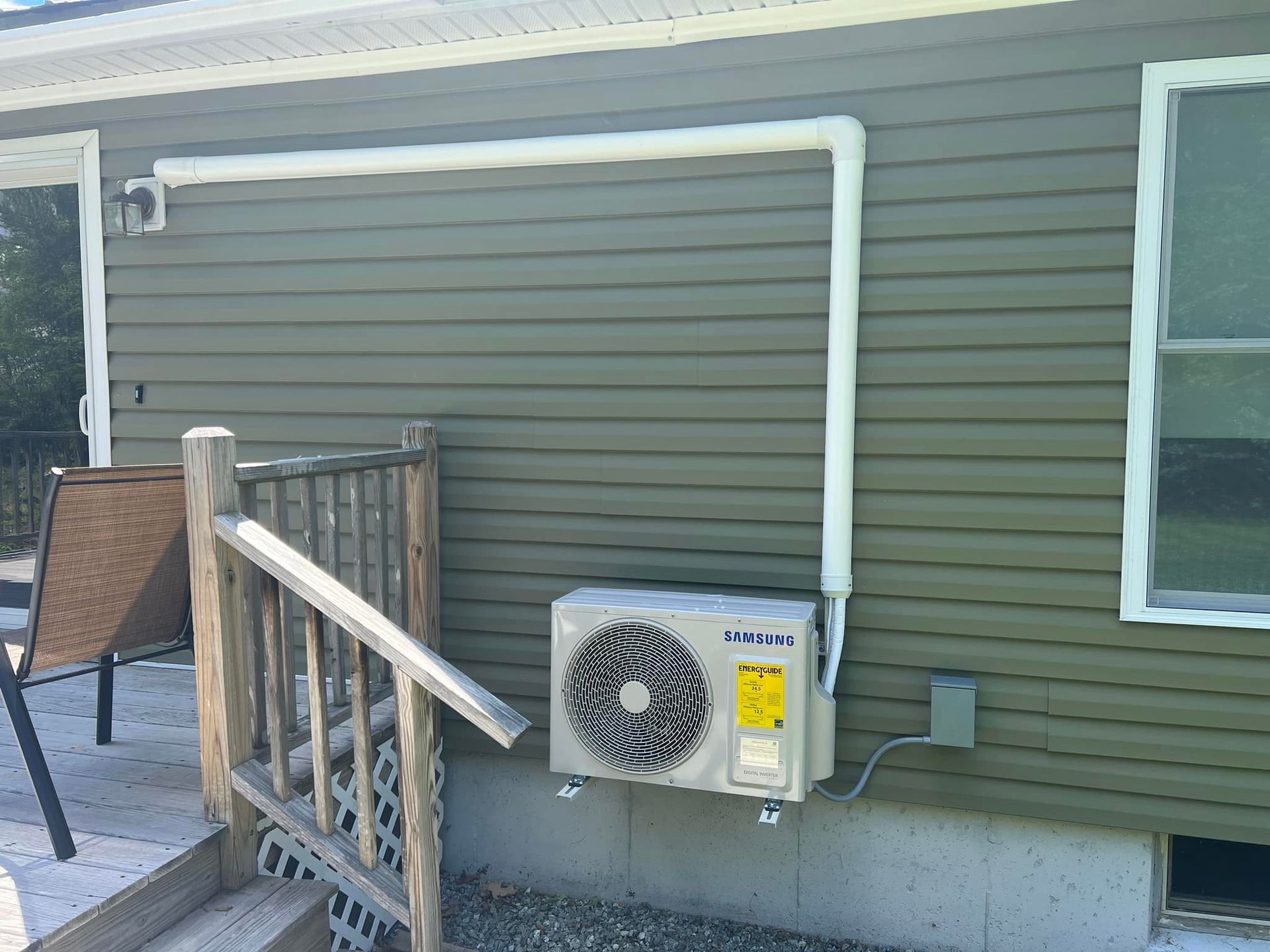 An air conditioner is mounted on the side of a house