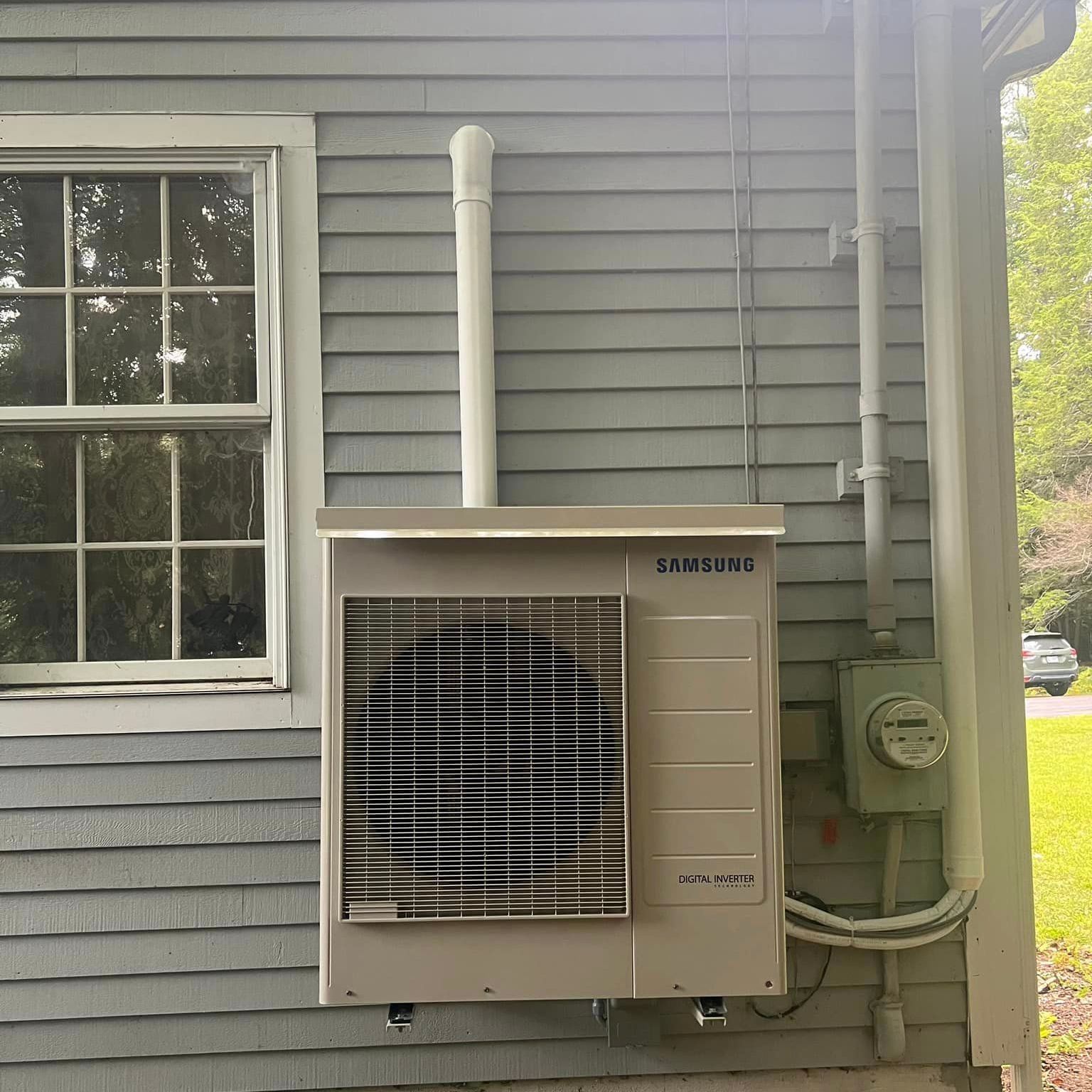 A row of air conditioners are lined up in front of a building