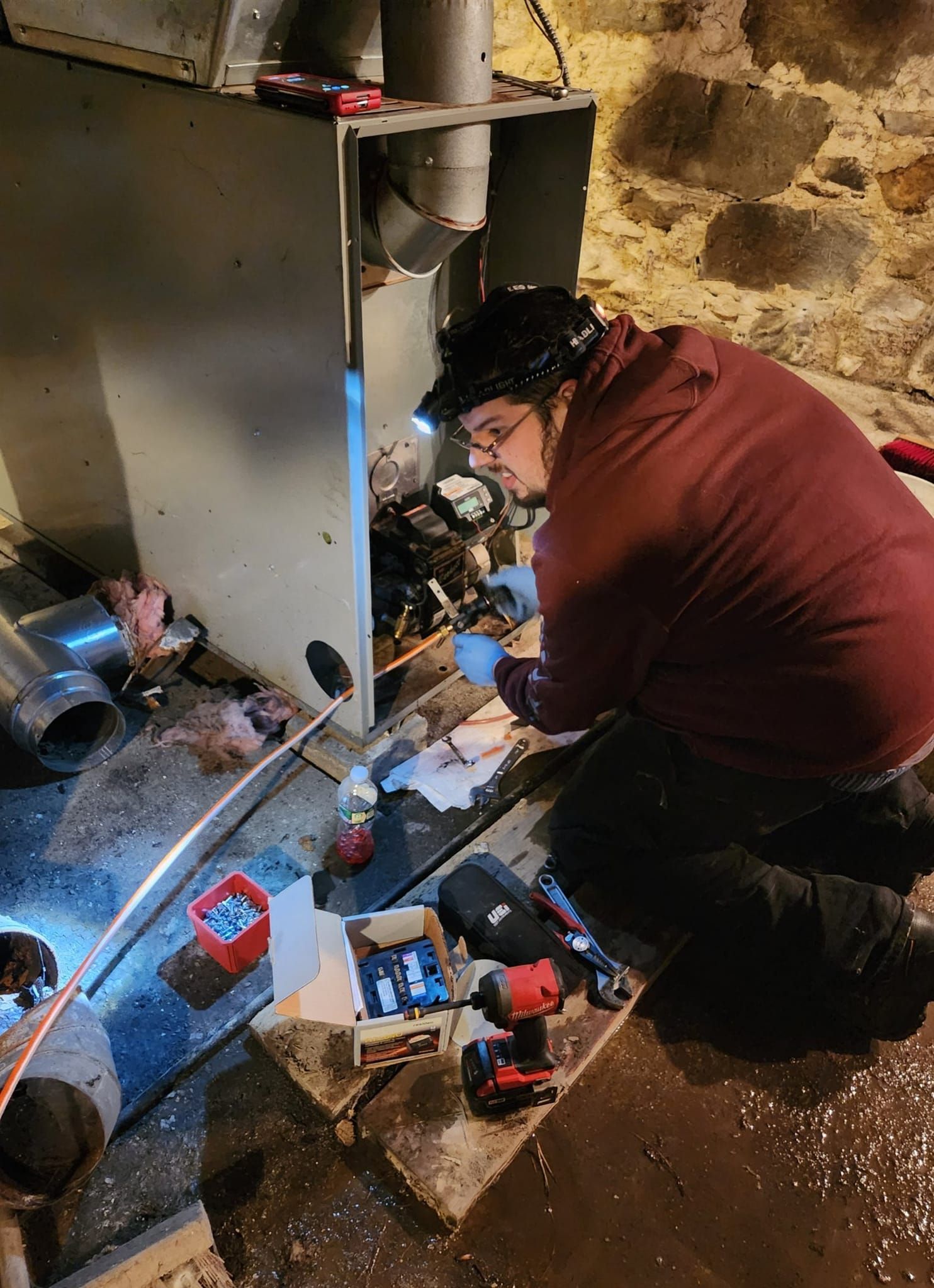 A man is working on an air conditioner while a woman takes notes.