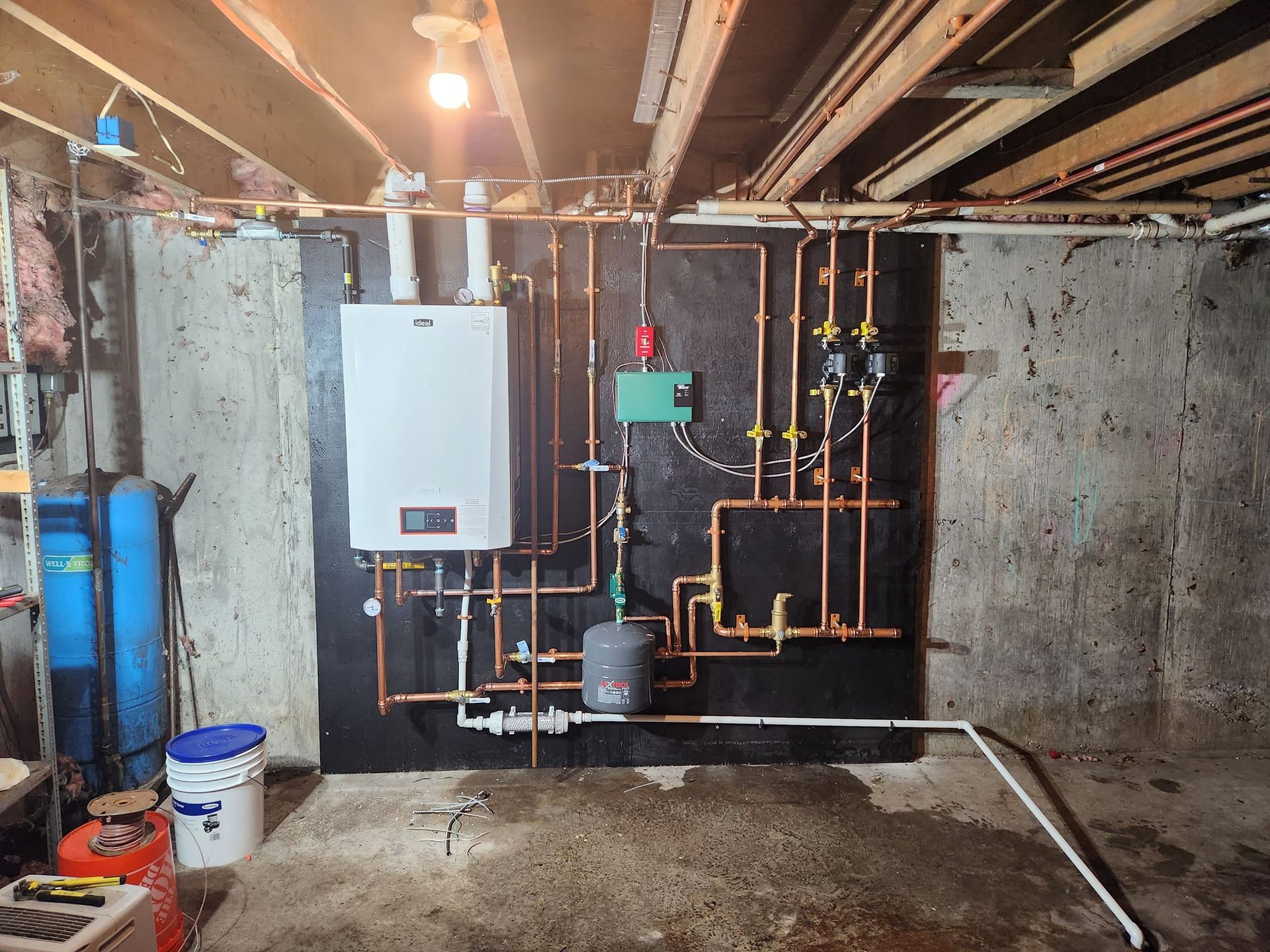 A room with a water heater and a furnace in it.