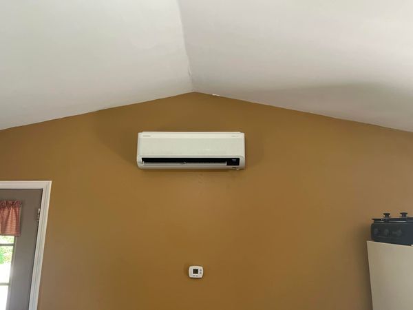 A white air conditioner is mounted on a wall in a room.