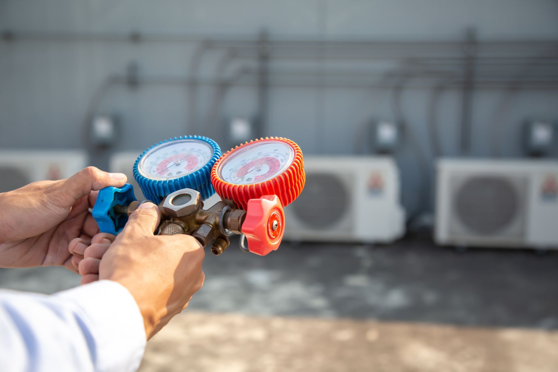 A man is holding a pair of gauges in his hands.