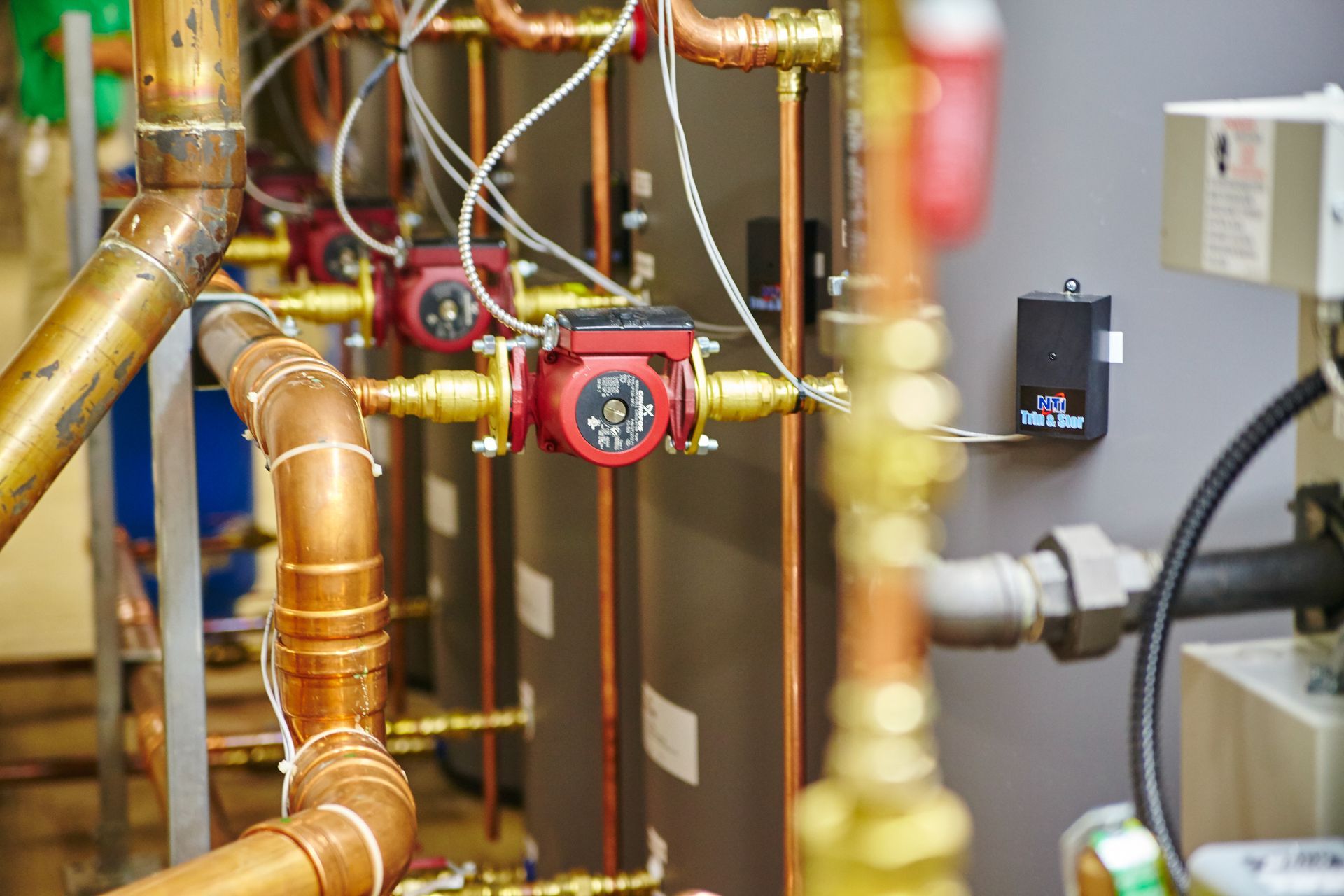 A row of copper pipes and pumps in a room.