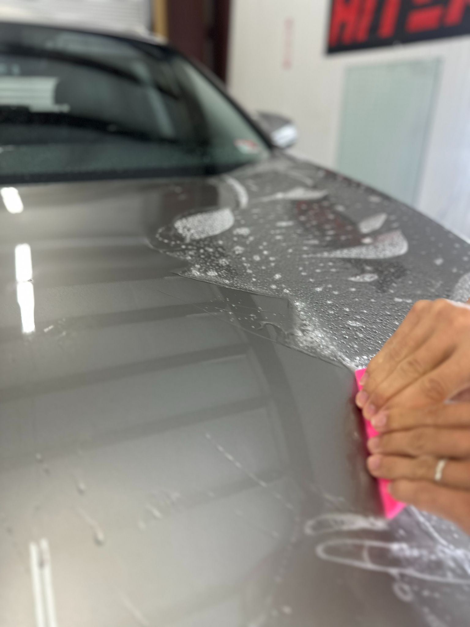 A sleek Lexus undergoing Paint Protection Film (PPF) installation on its front end for enhanced durability and protection.