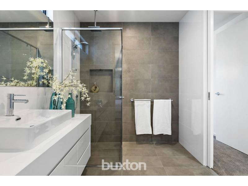 A bathroom with a walk in shower and a sink