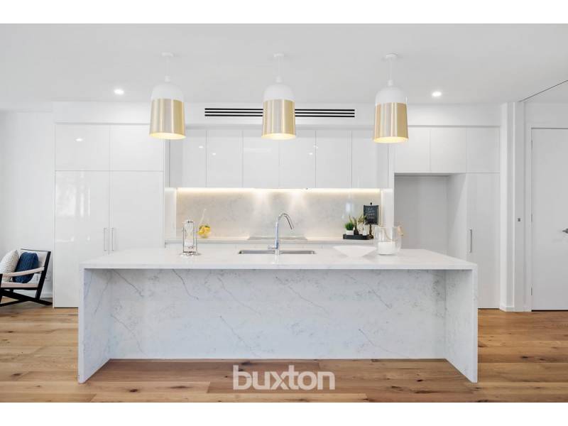 A kitchen with a large island and white cabinets