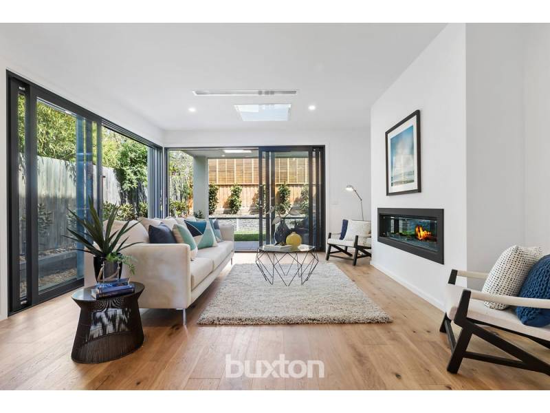 A living room with a couch , chairs , table and fireplace.