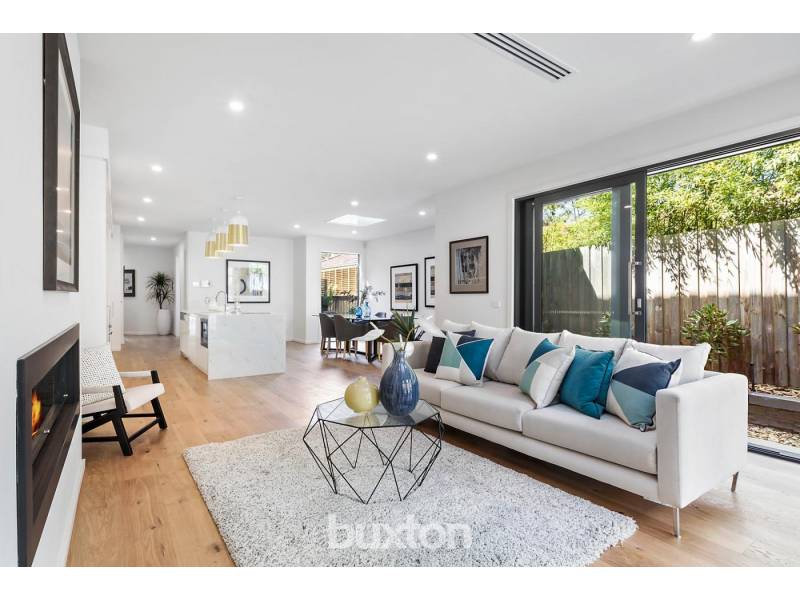 A living room with a couch , table , chair and fireplace.