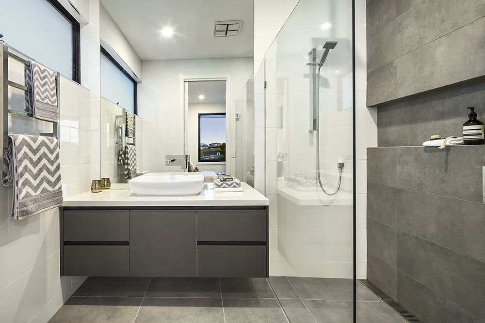 A bathroom with a sink , tub , shower and mirror.