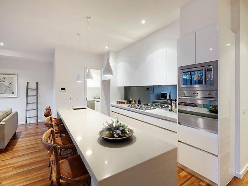A modern kitchen with white cabinets and stainless steel appliances