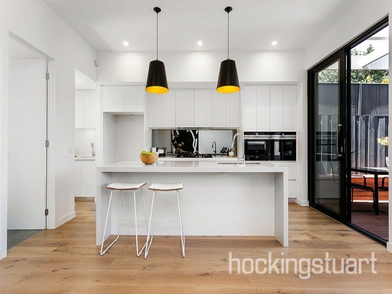 A kitchen with a large island and two stools