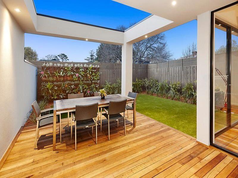 A wooden deck with a table and chairs on it
